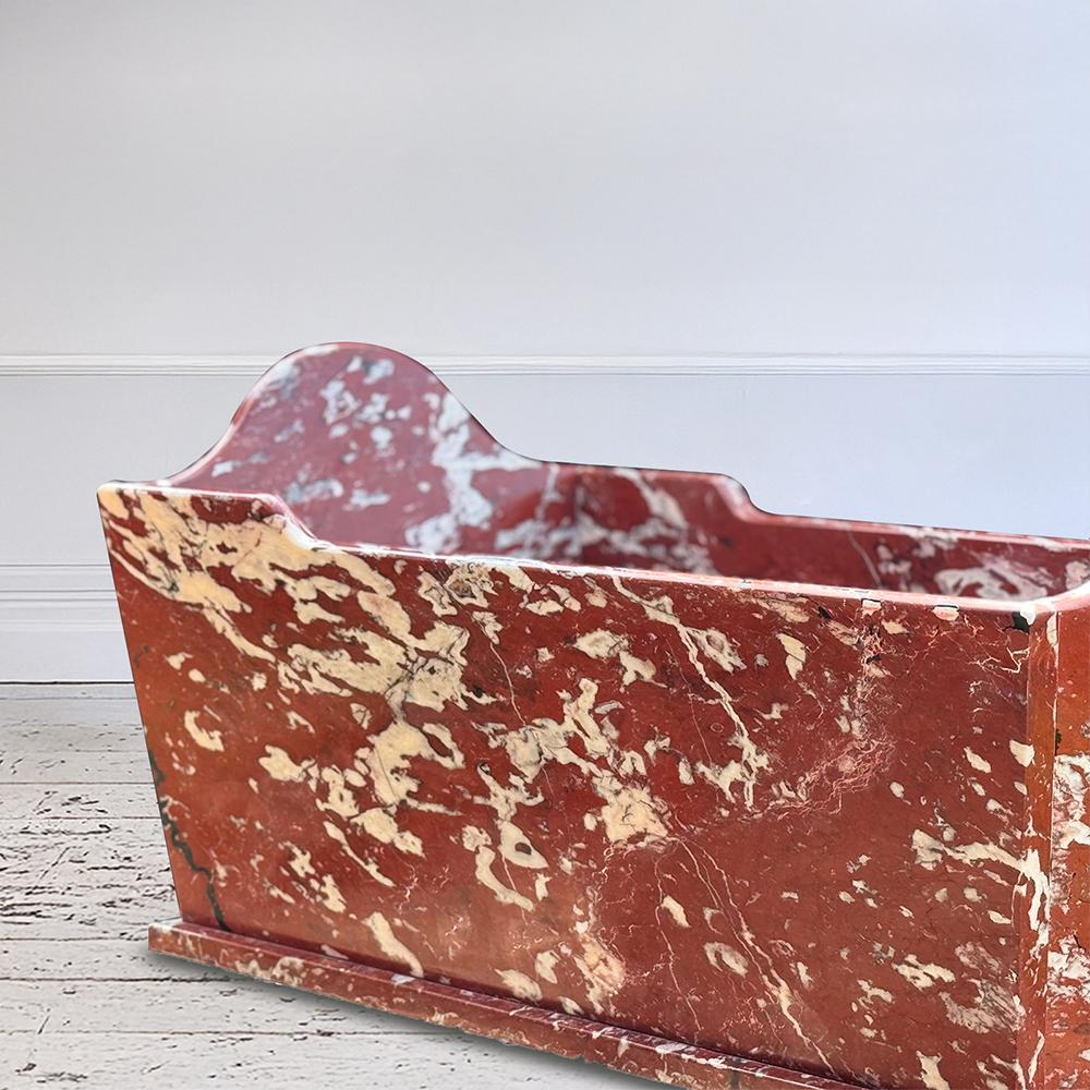 Esempio maestoso del lusso europeo del XIX secolo, questa vasca in marmo belga Rouge è stata scolpita a mano alla fine del 1800 e un tempo abbelliva un prestigioso castello francese.  Rinomato per il suo vivido colore rosso cremisi e per le sue