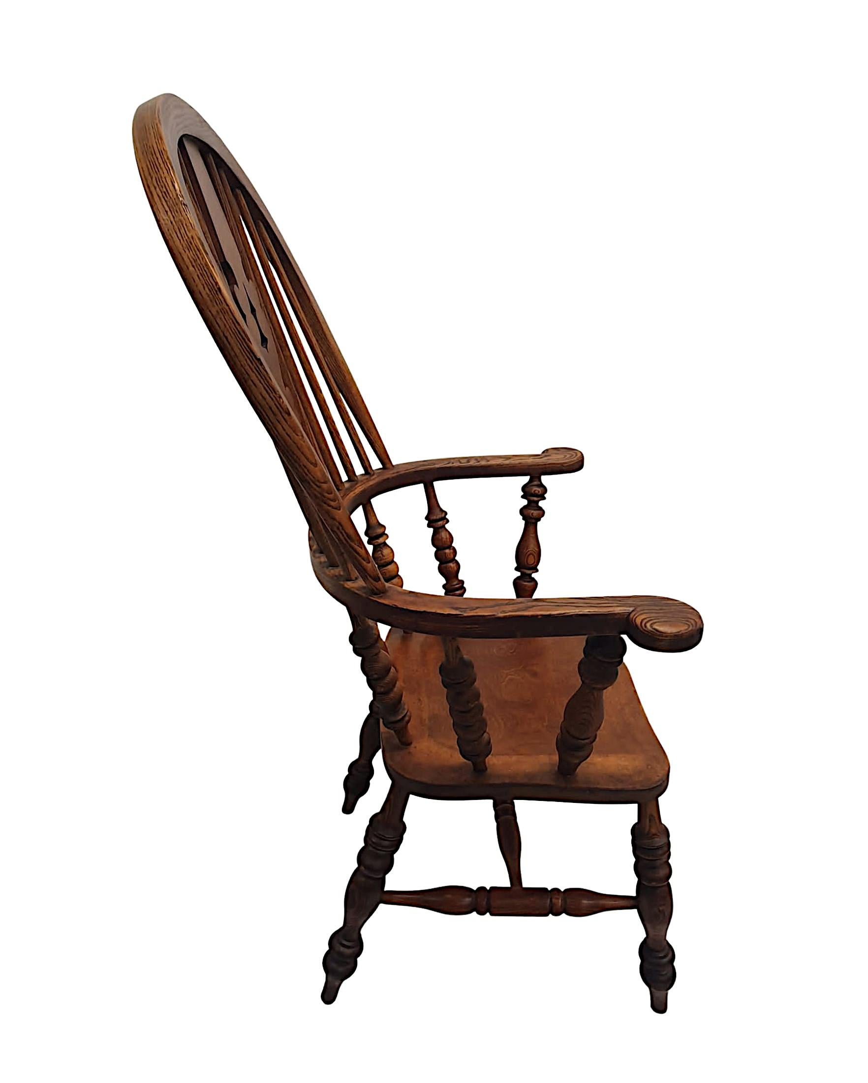 Rare fauteuil Windsor en frêne et orme du XIXe siècle, à larges accoudoirs, d'une qualité exceptionnelle, finement sculpté à la main, avec une patine et un grain d'une grande richesse. Le haut dossier en forme d'arceau est doté d'un dosseret central