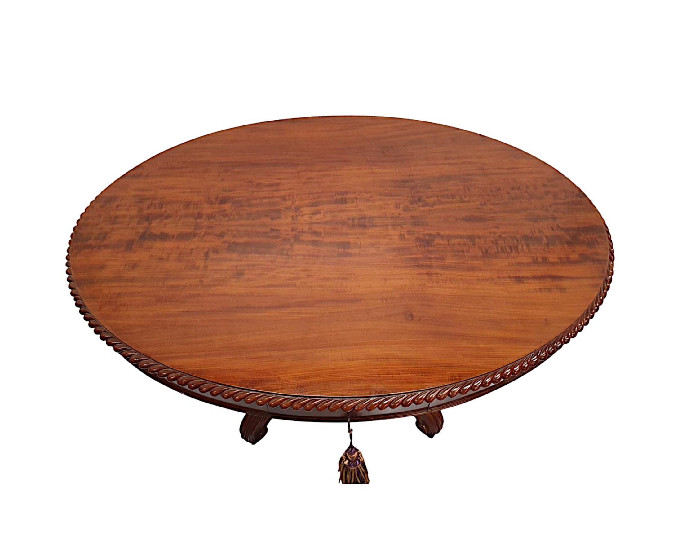A rare 19th Century figured mahogany drum table, finely hand carved and of exceptional  quality with rich patination and grain.  The well figured, moulded top of oval form with beautifully detailed gadroon edge is raised over a classically simple