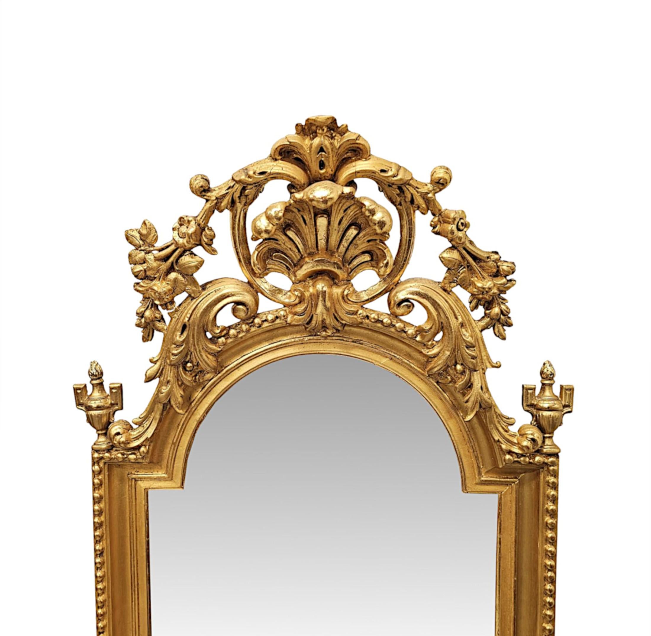 Raro specchio da molo o da sala in legno dorato del XIX secolo di qualità eccezionale con un grande cartiglio a conchiglia. La lastra di vetro a specchio di forma rettangolare e con il piano curvo è inserita in una cornice in legno dorato finemente