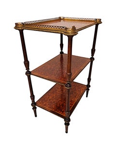 Un raro mueble auxiliar de tres niveles del siglo XIX con incrustaciones de marquetería y detalles de monturas de bronce dorado