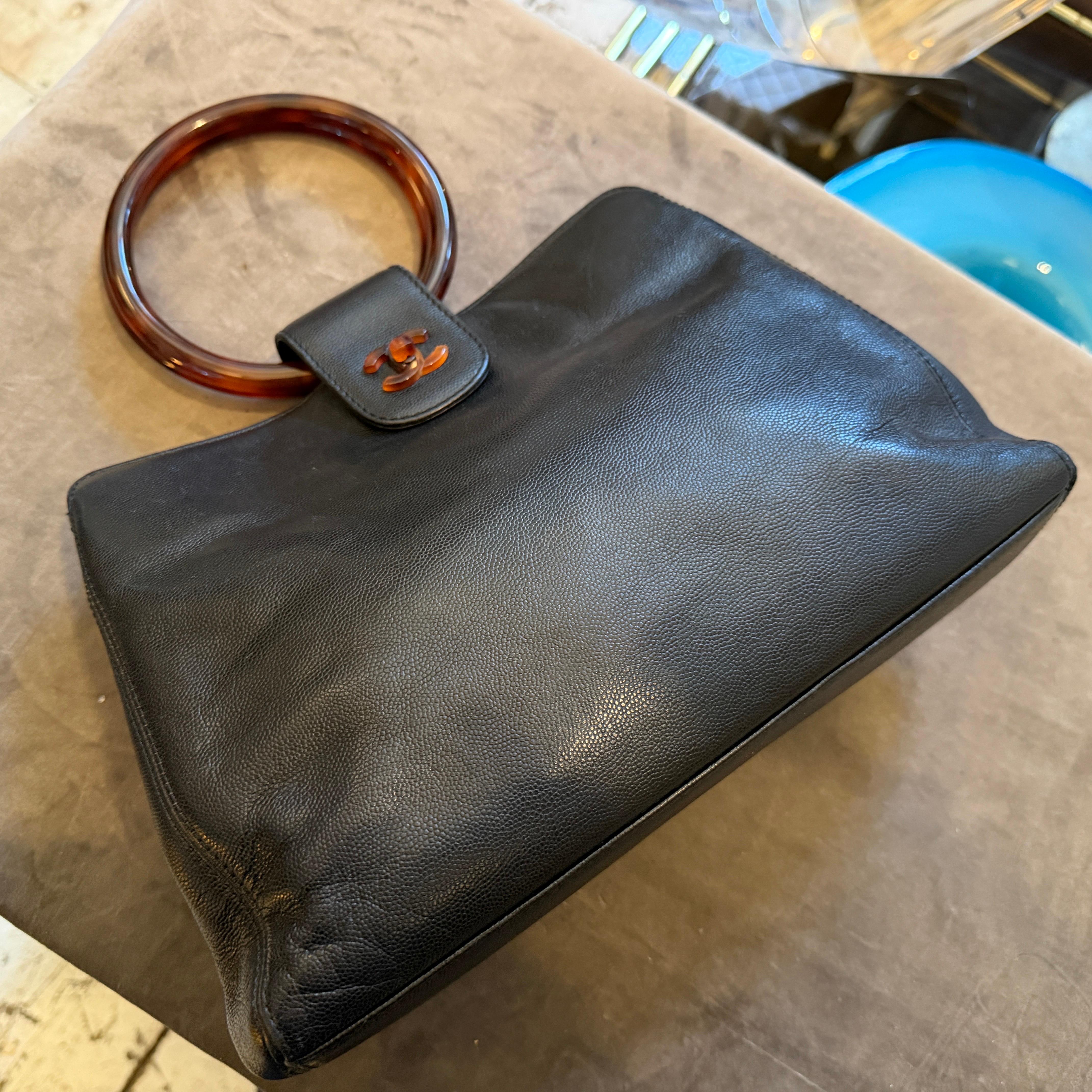 Il s'agit d'un sac à main vintage Chanel de la fin des années 1990 au début des années 2000, confirmé par son design distinctif et son code de série. Ce sac structuré à poignée supérieure est fabriqué en cuir Caviar noir, réputé pour sa finition