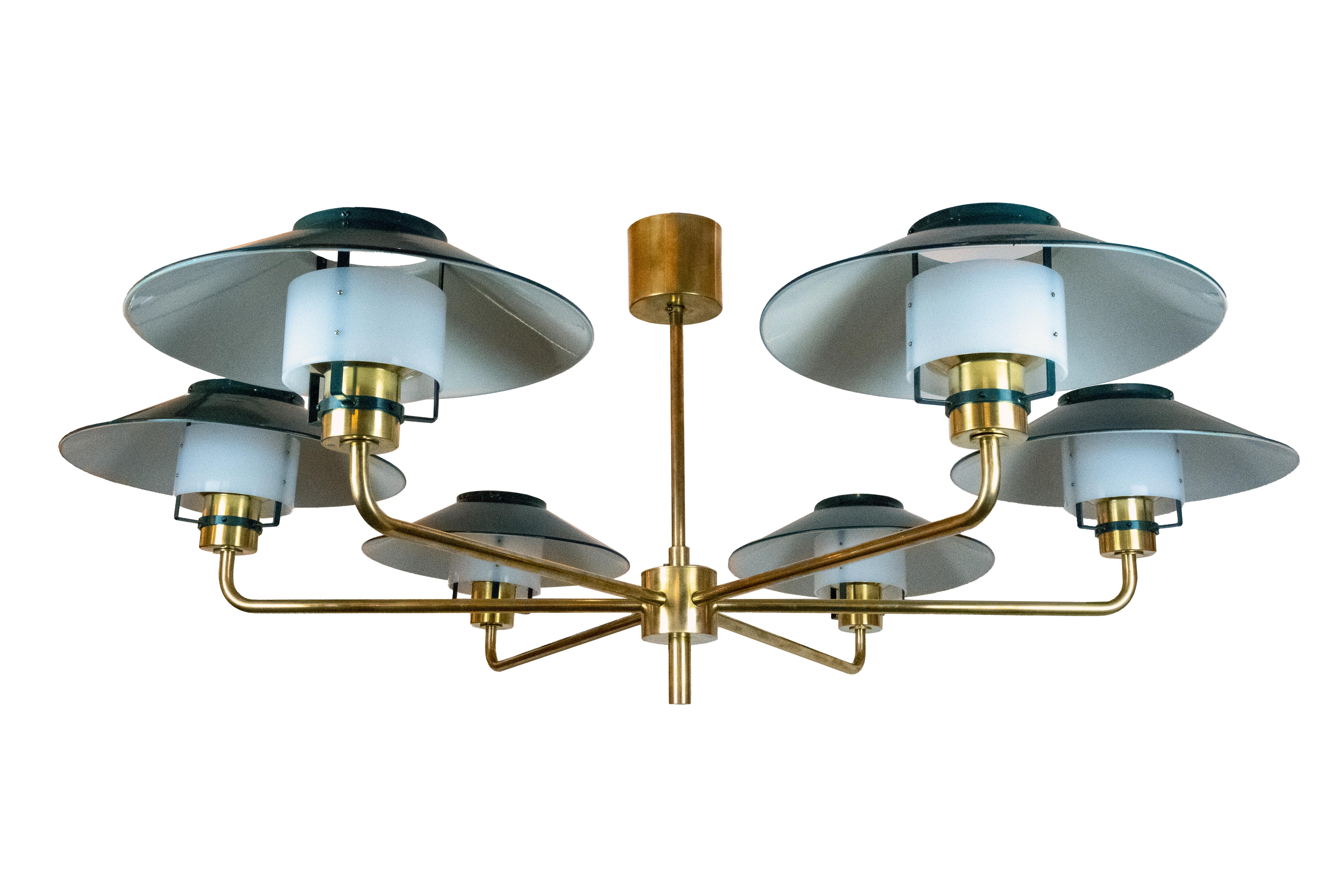 Un raro e grande lampadario a sei luci del designer svedese Hans-Agne Jakobsson (1919 - 2009) per Markaryd. I sei bracci in ottone con paralumi in metallo verniciato nascondono ciascuno una presa media con una potenza massima di 100 watt. Le tende
