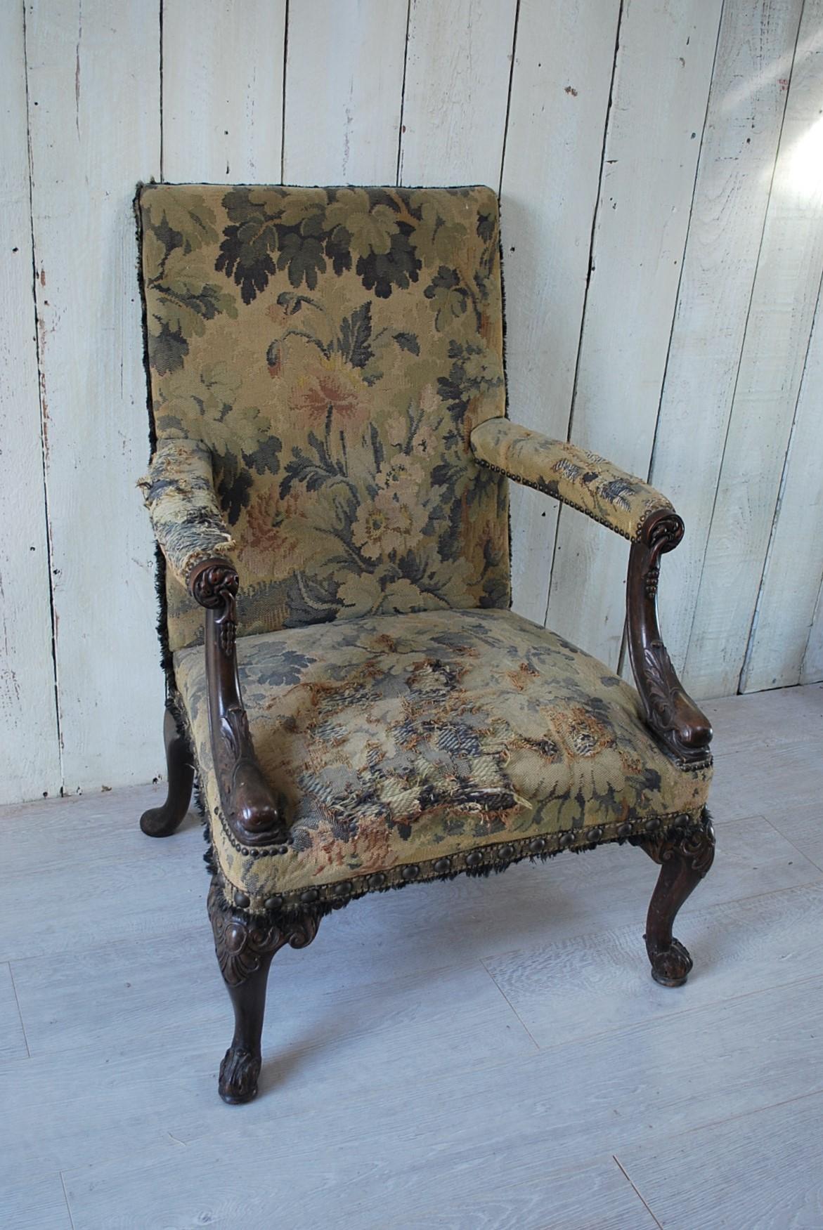 A rare and unusual American Gainsborough armchair with country house worn tapestry, in an 18th century manner. Lovely crisp deep carving of dolphins at the base of the arms and carved cabriole legs. To the underside is an old American retailers