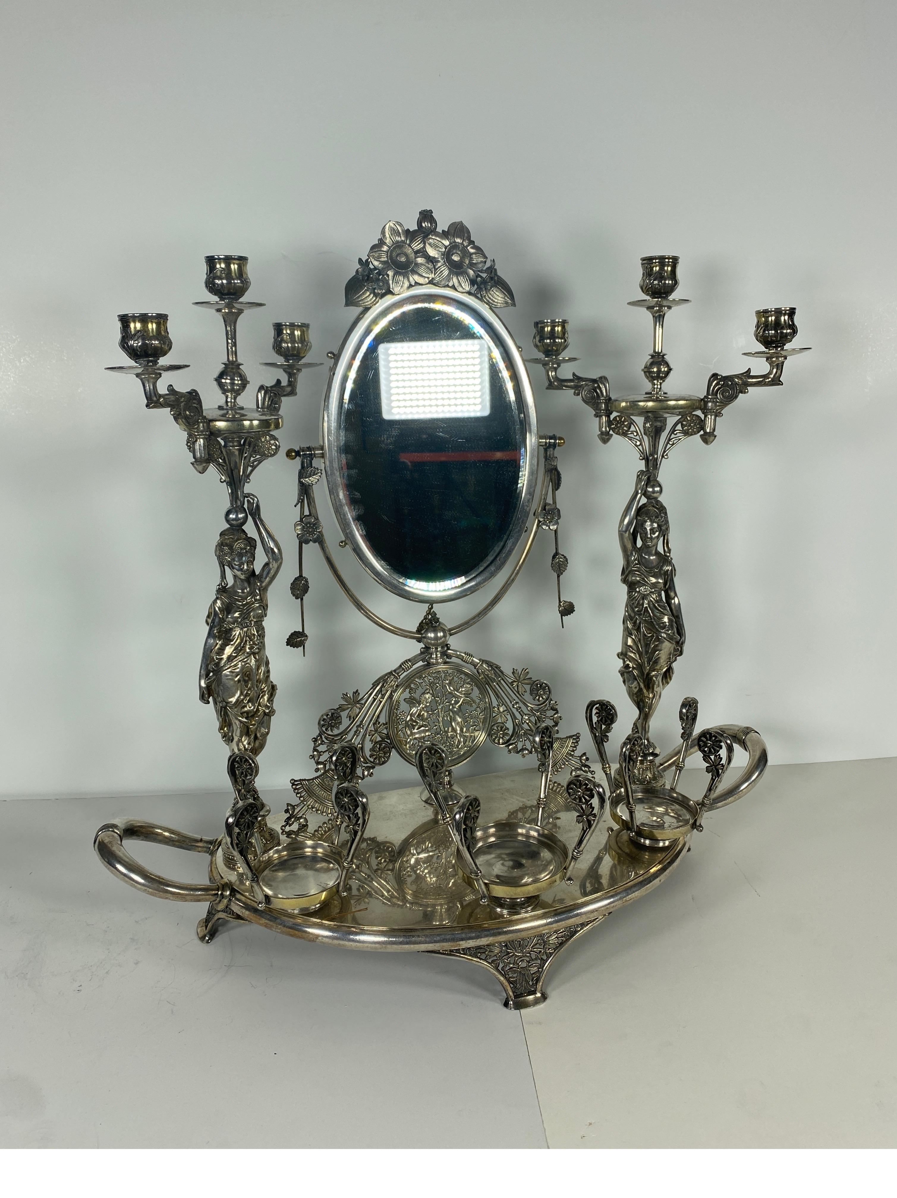 A rare American silvered bronze vanity toilet set by Meriden, circa 1870

Beautifully cast with two fully robed maidens holding up a 3 branch candelabra. The central oval mirror with gilt highlights and a floral Victorian finial. The bottom