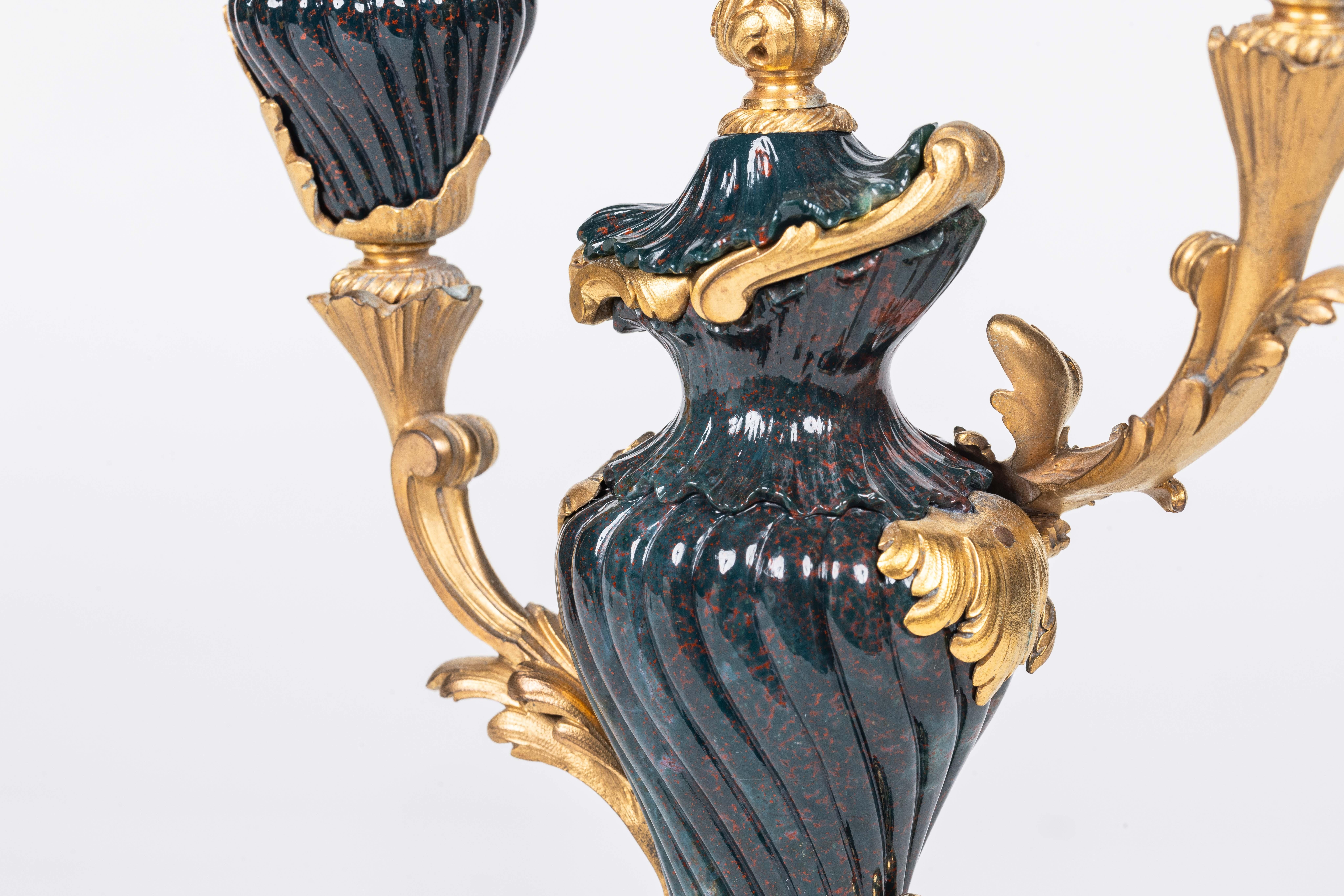 A Rare Pair of Ormolu-Mounted Bloodstone Two-Light Candlesticks, Resting on Jasper Bases, Circa 1790

Transport yourself to the pinnacle of historical elegance with this extraordinary discovery - a truly rare and exquisite pair of ormolu mounted