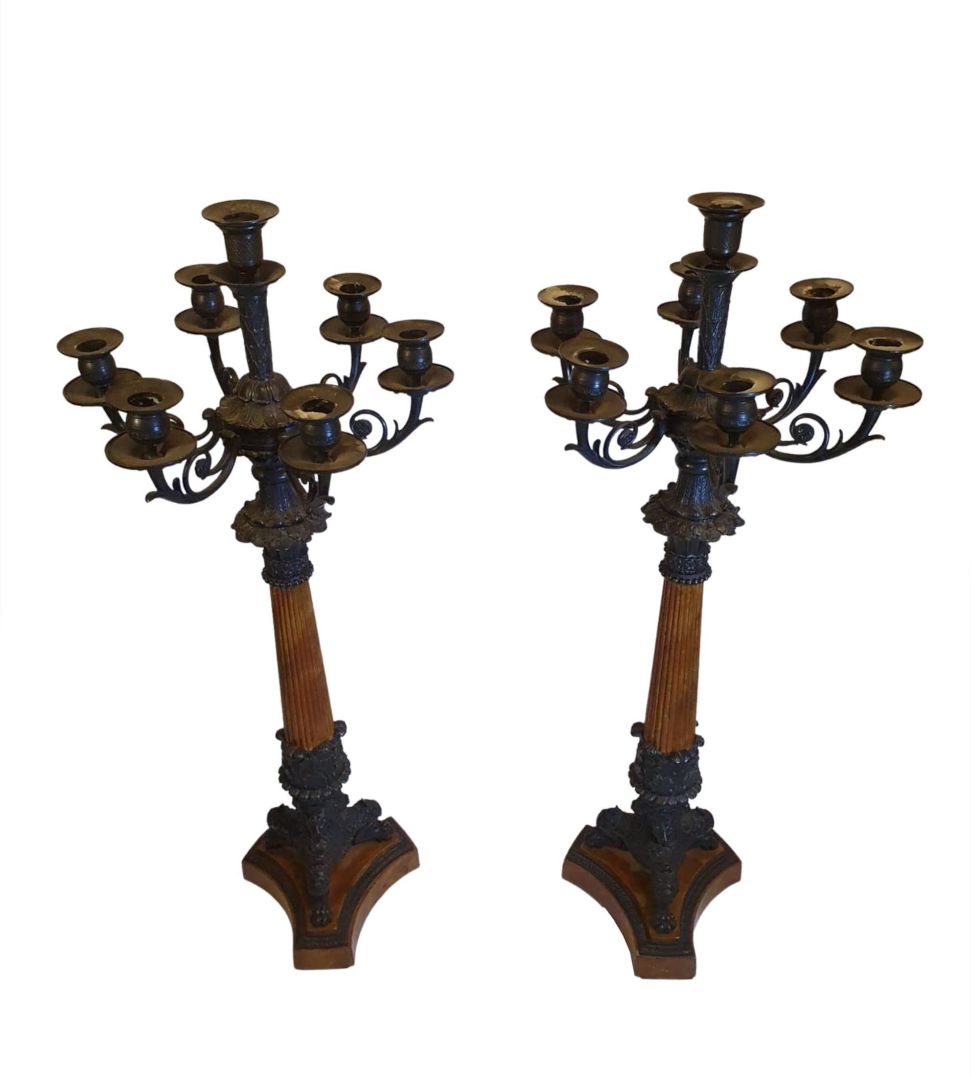 Une paire rare et raffinée de candélabres à sept branches en bronze du XIXe siècle de style Empire, avec des motifs complexes de volutes et de feuillages, avec une tige colonne cannelée soutenue par un pied triforme en forme de pattes, se terminant