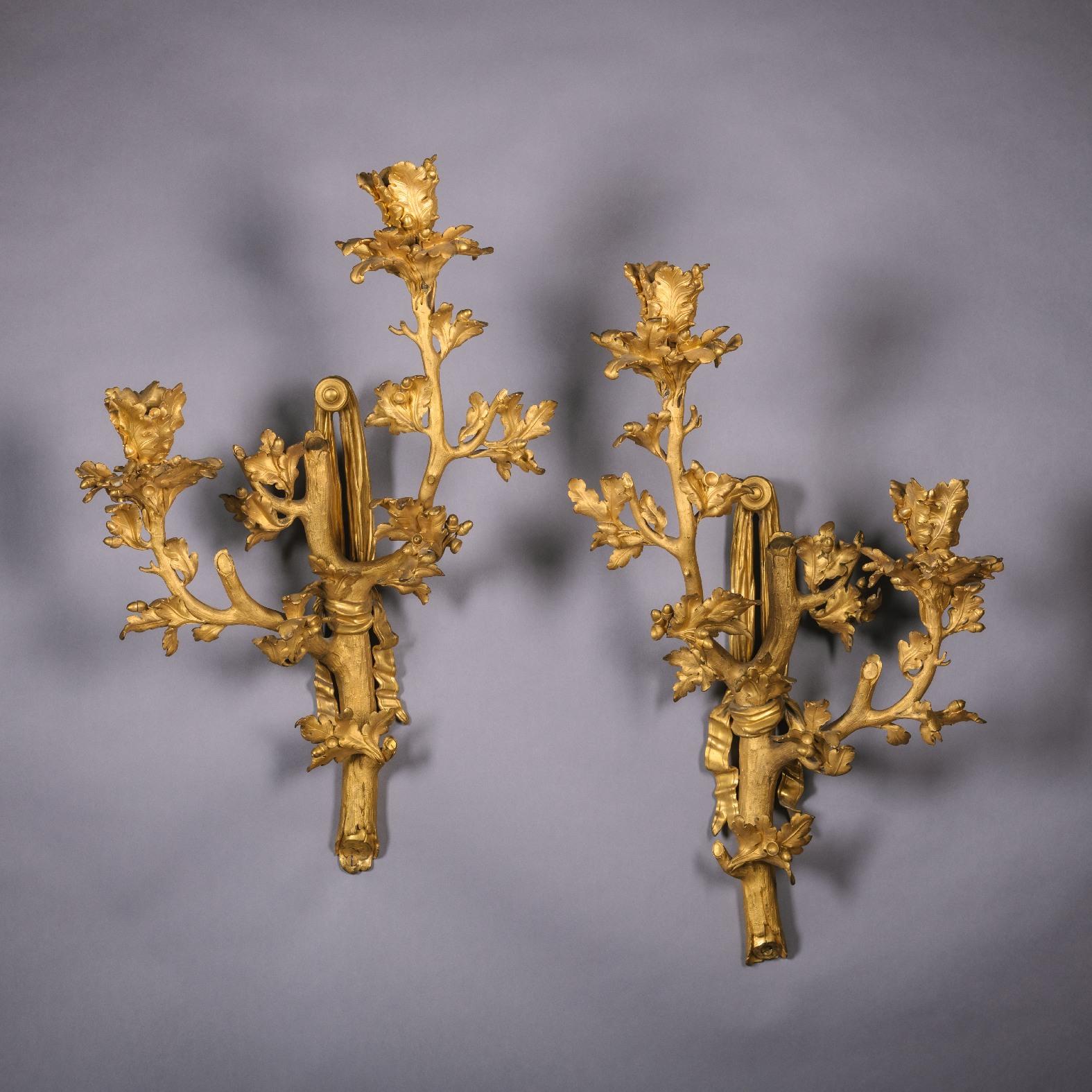 Ein seltenes und höchst ungewöhnliches Paar vergoldeter bronzener Wandapplikationen mit zwei Lampen. 

Frankreich, ca. 1870.

Sie sind im hohen Rokoko-Stil Ludwigs XV. als Zweige aus Eichenlaub und Eicheln modelliert, die an mit Bändern gebundenen