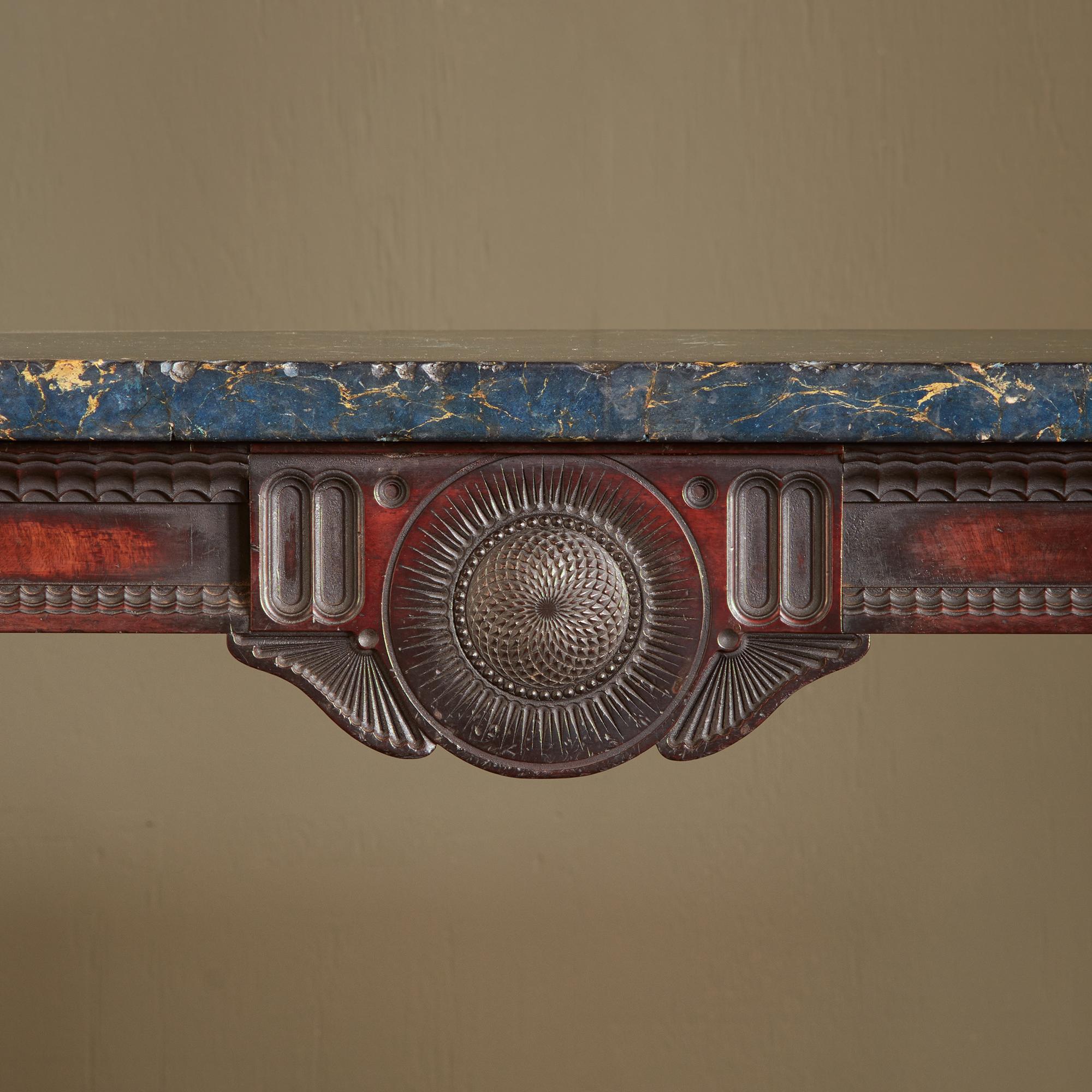 With exceptional overall colour, and blue scagliola marble top, the extensive carving details with hugely imaginative quality in the Egyptian manner, with finely carved frieze and a pair of spiral moulded and stop fluted columns, united by a