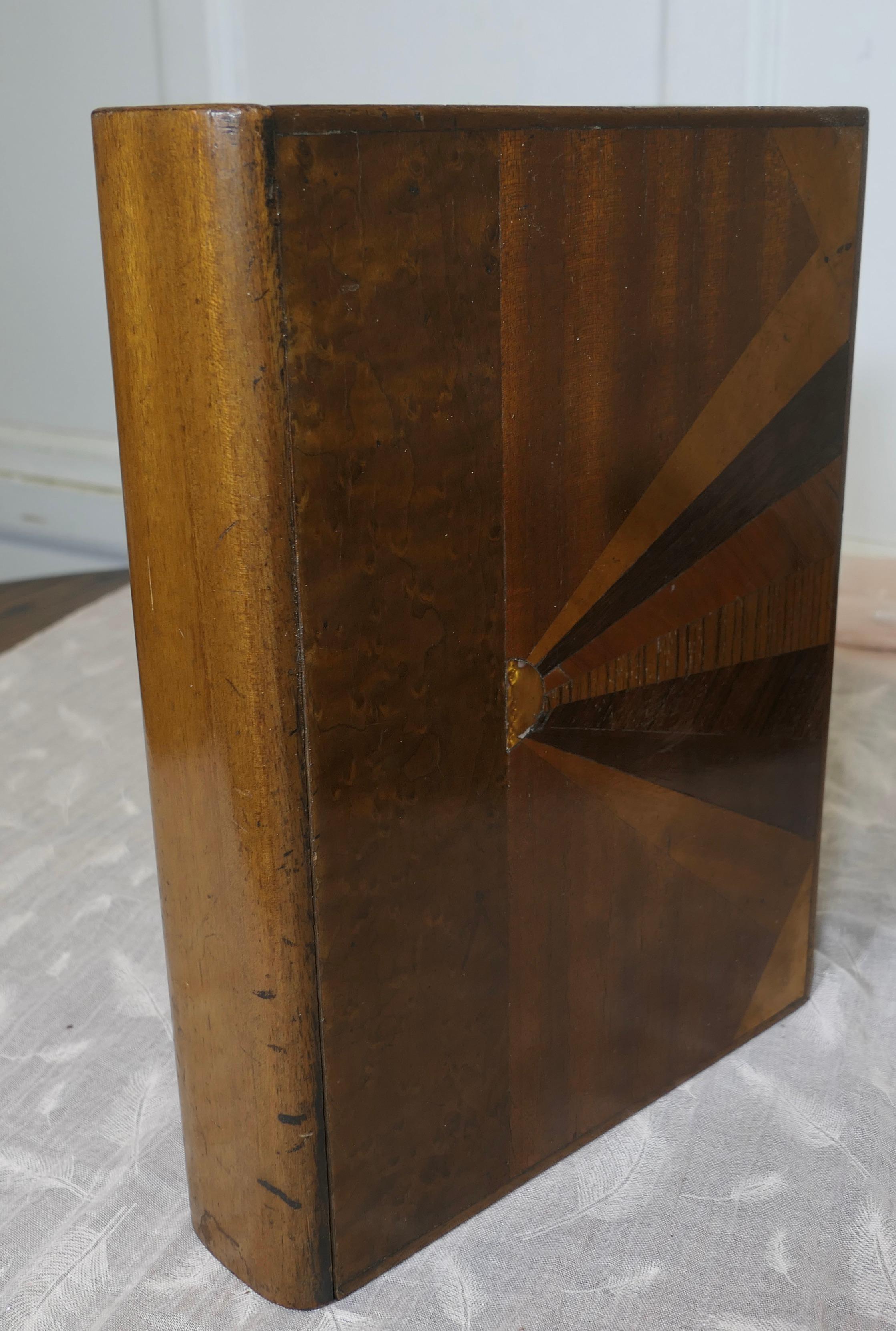 Un raro libro cassaforte segreto in stile Art Déco Odeon

Si tratta di un pezzo molto attraente, con una decorazione a intarsio in stile Odeon a forma di scoppio di sole.
Quando è posizionato sulla libreria sembra un libro molto attraente, ma il