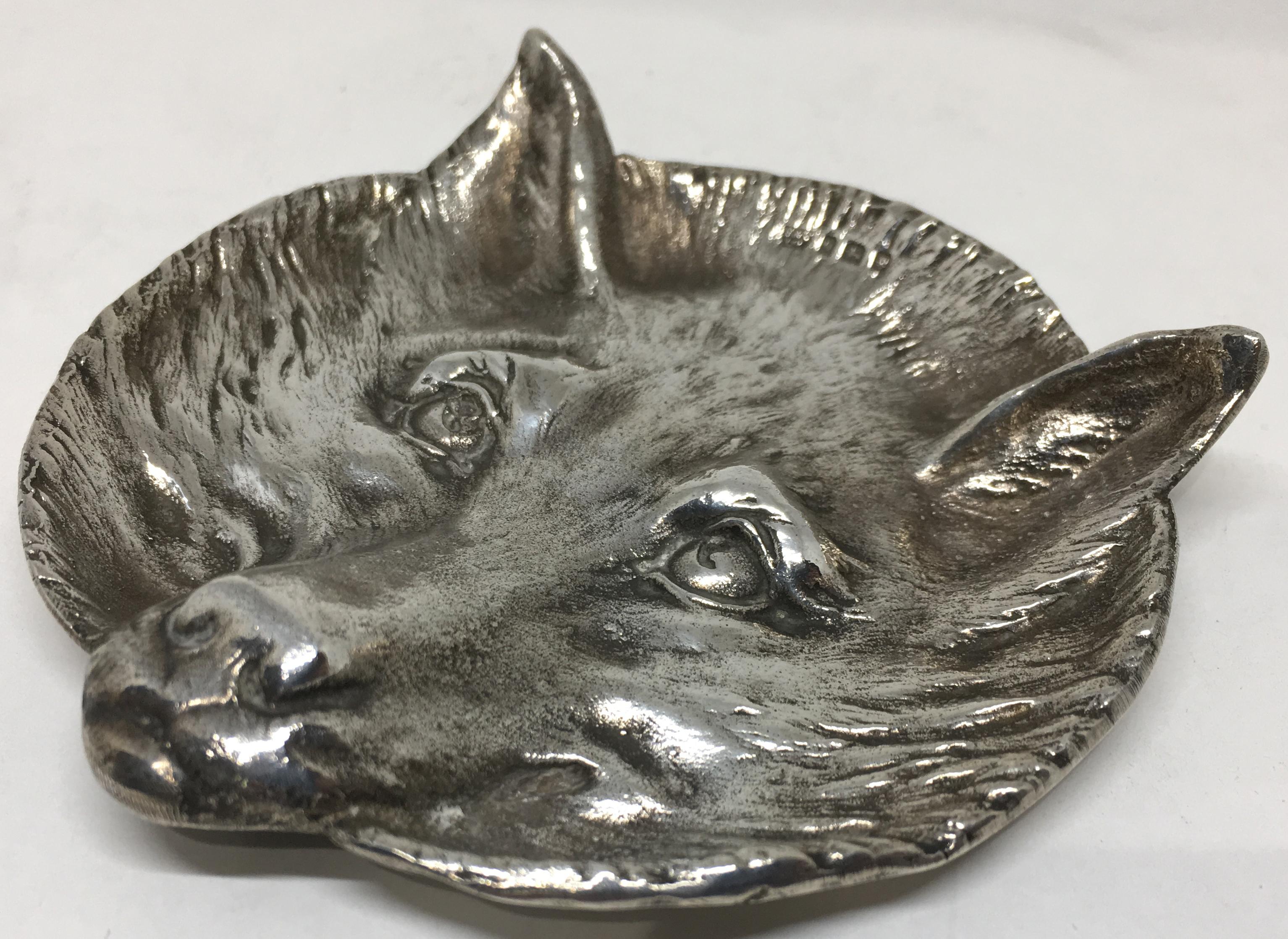 A very rare sterling silver card tray, retailed by Asprey styled, in relief, as a fox head.

Dated with the makers hallmark for London 1931 and stamped on the reverse with the retailers mark of 