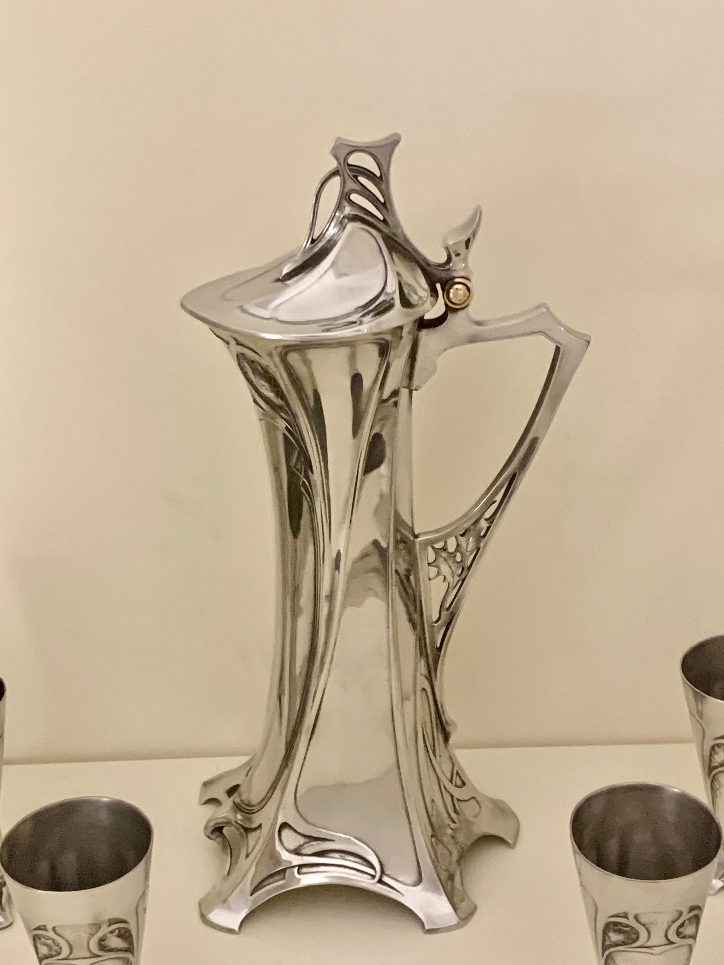 Silver-plate liqueur set comprised of a Stylised liqueur Jug with six Tumblers. Country of Manufacture Germany Date c.1900 Marks Marked to base Condition is Professionally Polished, Perfect with no faults and ready for immediate use. Size Jug 37 cms