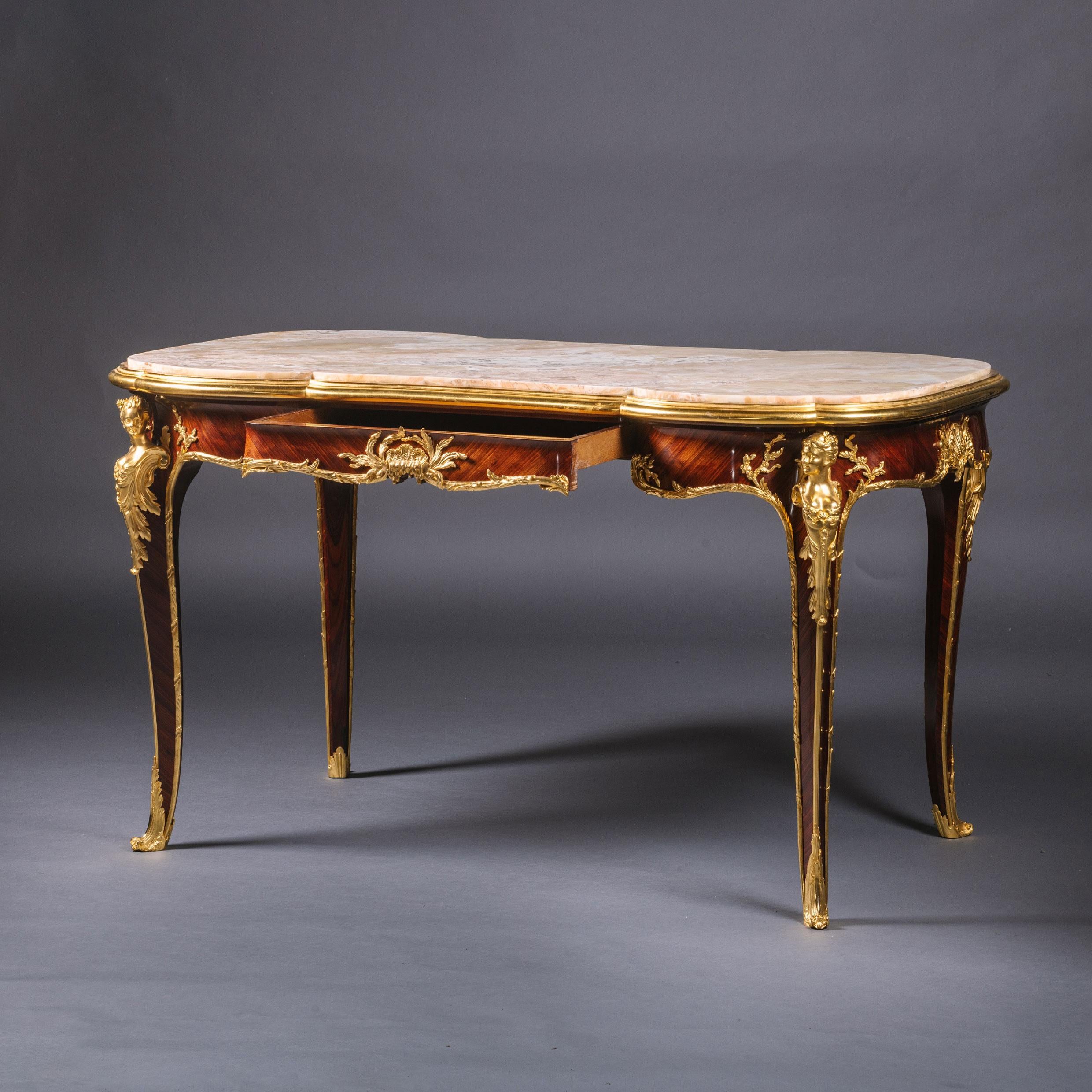 A Rare Belle Epoque Gilt-Bronze Mounted Parquetry Inlaid Centre Table, By François Linke. The Mounts Designed by Léon Messagé. 

Signed 'F. Linke'.

This opulent centre table has a beautifully patterned onyx top inset within a gilt-bronze moulded