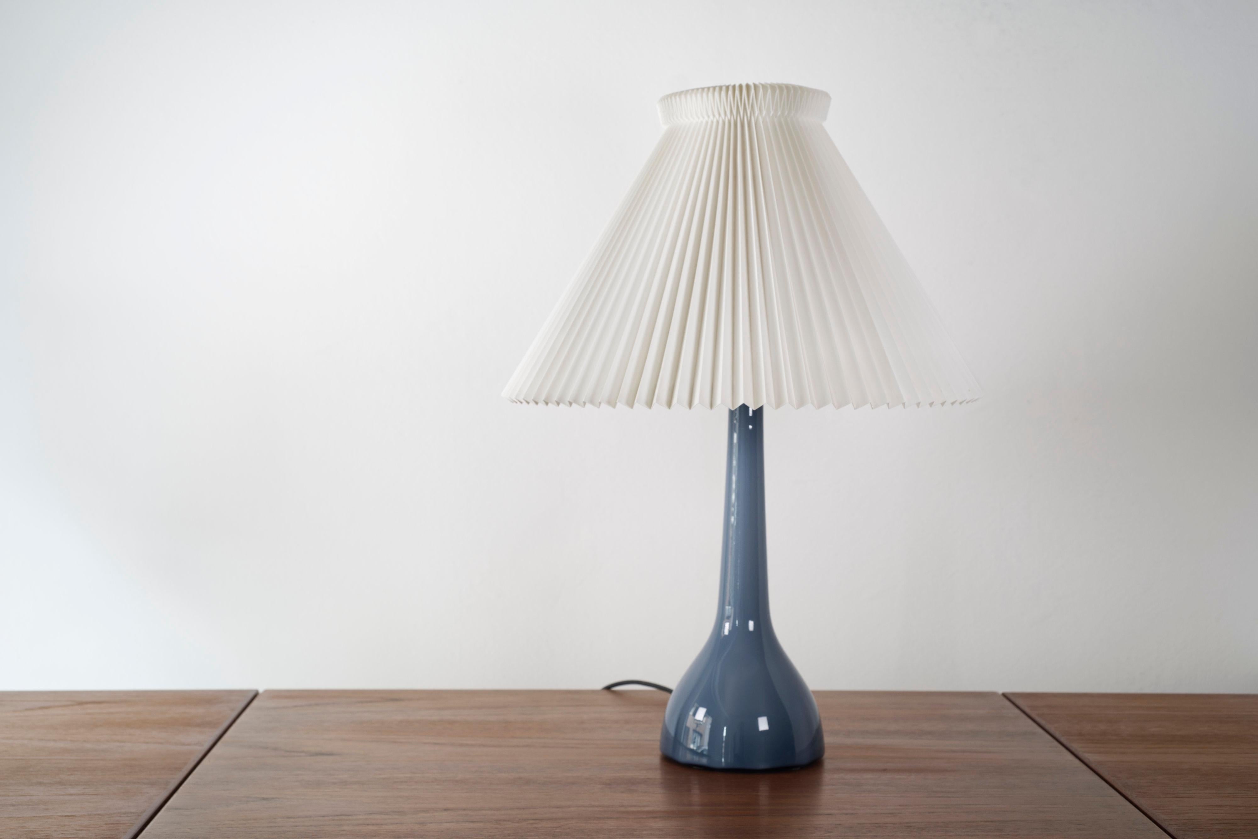 A rare blue Danish midcentury table lamp by Esben Klint for Karstrup Holmegaard Fyns Glasværk, 1950s.

Beautiful blue coloured glass with a swirl effect of darker and lighter shades. This model and shape is very uncommon and features very slight