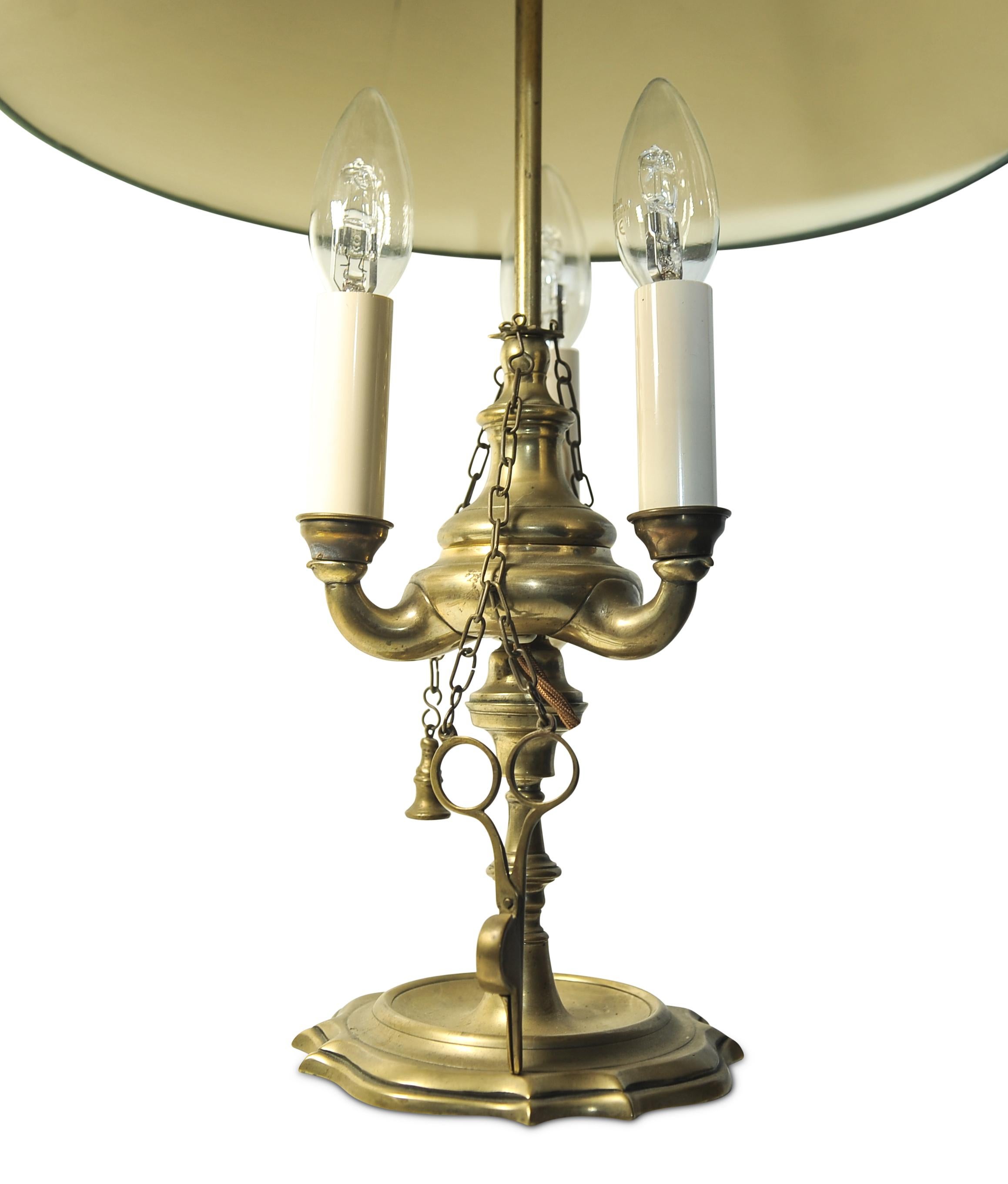 A Rare Brass Bouillotte Triple Branch Table Lamp With An Adjustable Height Shade.
Complete with rare brass accessories such as a candle snuffer and candle wick cutter. 

Item has been converted to be a modern lamp, from an original candle lamp.
