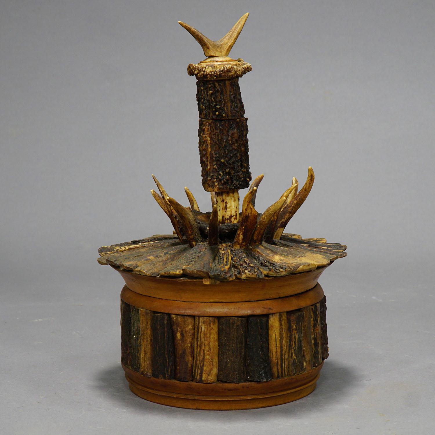 Rare Cabin Decor Antler Humidor, circa 1890-1900

An antique turned wooden box with lid, venered with several fine antler slices from the deer and decorated with tips of roe deer antlers. (woodcrack at the lid - see pictures). On top of the lid with
