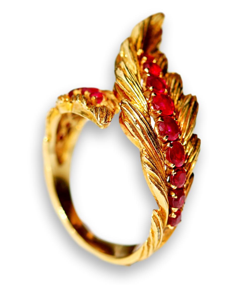 This ring seems to be a rare one. It is a design from around the 1950s with really detailed gold work. You would be extremely unlucky to meet somebody else wearing the same ring as you. 

It is set with a spine of deep pinkish-red rubies on each