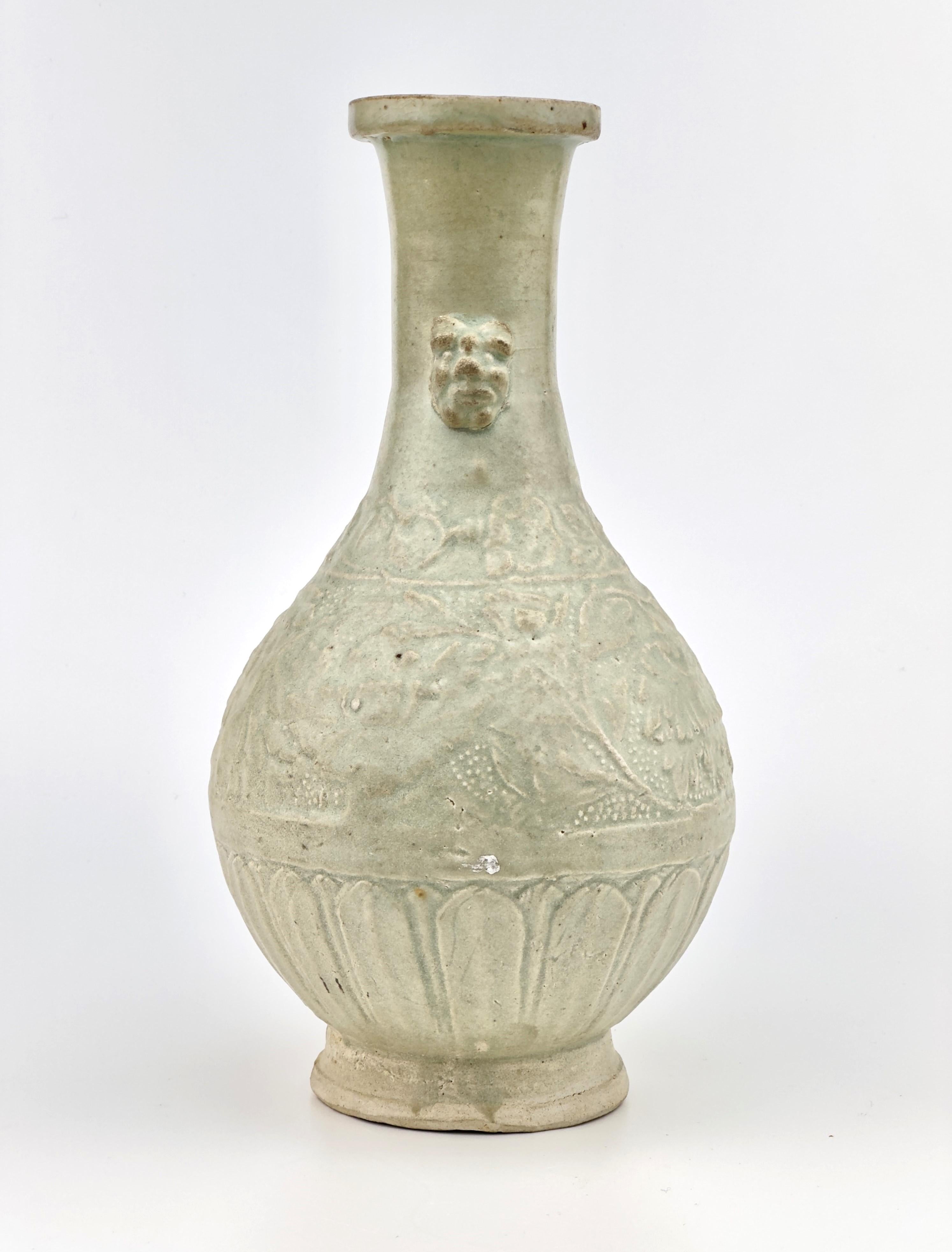 The vase is raised on a slightly splayed foot and flanked on the tall cylindrical neck by a pair of mask handles. The body is molded with lotus scroll pattern between a floral scroll band and an petal lappet band.

Period : Song-Yuan