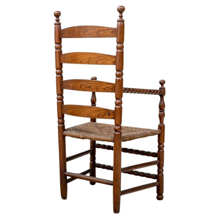 Fabriqué par Chamberlain Company, New Haven CT, à partir d'un orme tombé sur la propriété de Yale. La chaise a été offerte par Yale qui avait reçu une chaise de pèlerin d'époque de la maison Trumbull. Dossier à lattes avec cadre tourné de façon