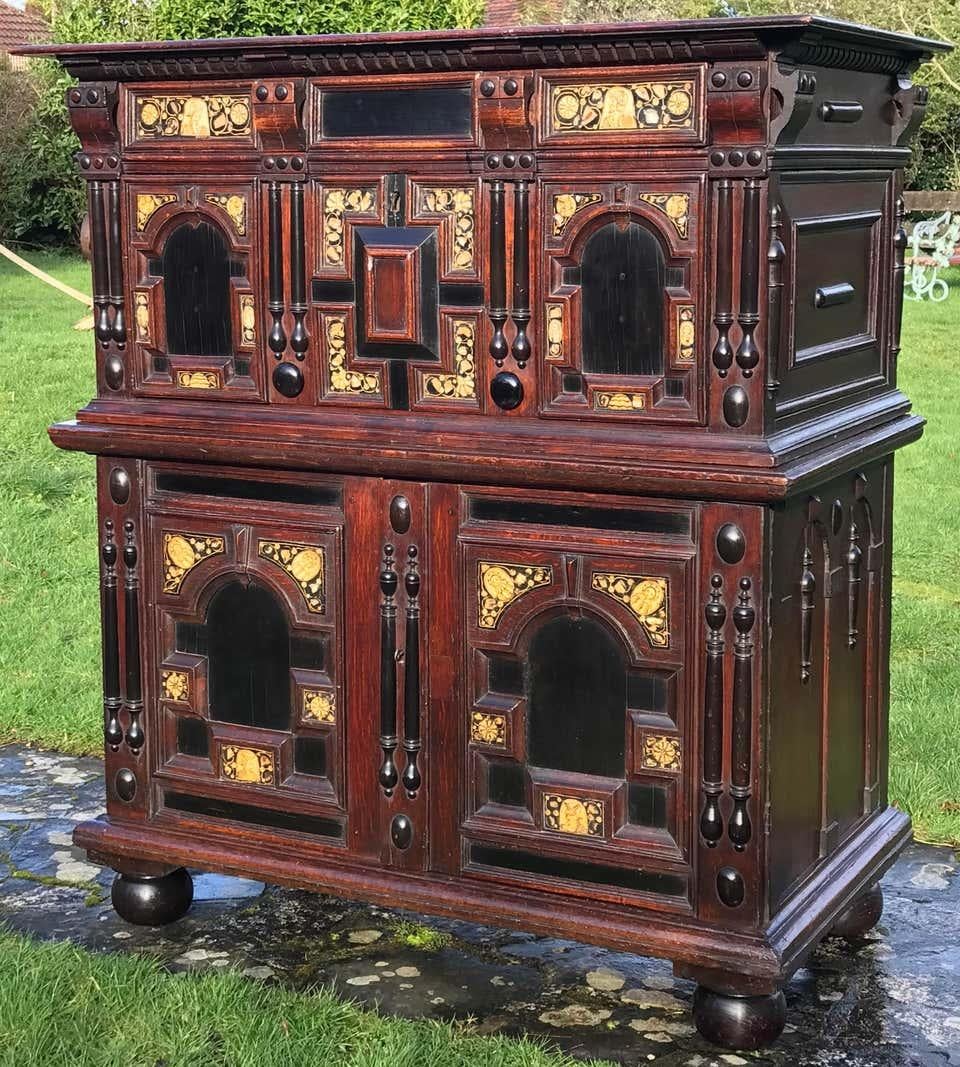 This exceptional 17th-century chest / cabinet has one long working drawer, and one deep drawer, with cupboards retaining internal shelving below. All faced with elaborate, mitred, geometric mouldings, applied split balusters, carved corbels,
