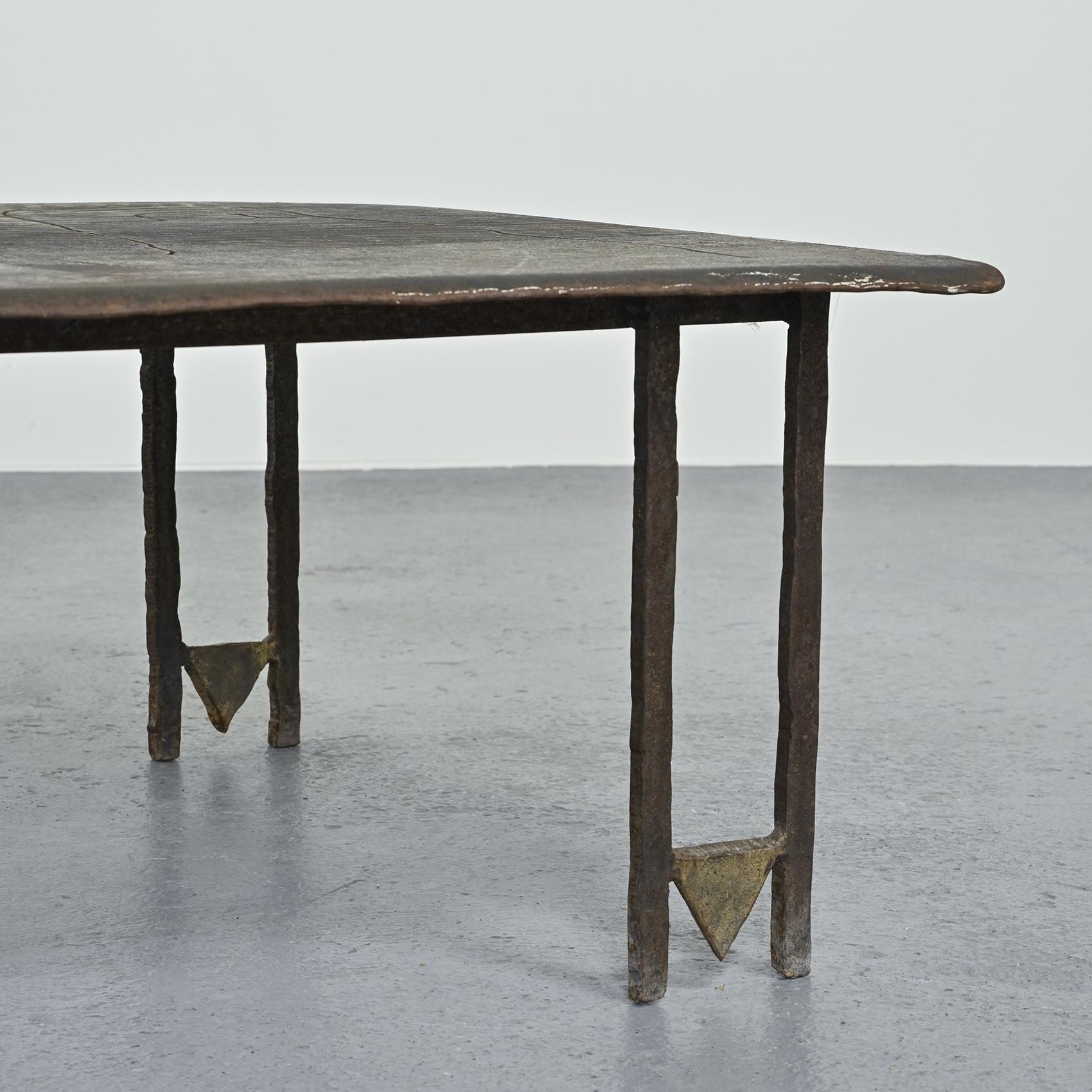
Rectangular-top coffee table by French sculptor Jean-Jacques Argueyrolles, circa 1990.

The model is in drilled and re-oxidized sheet steel, with parts worked in oxidized bronze leaf. The top features a pattern with stylized figures, and rests on