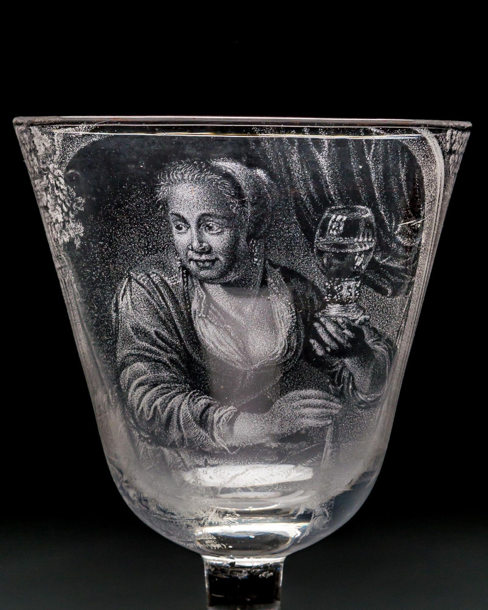 The round funnel bowl stipple-engraved with a half-length portrait of a female herring saleswoman holding up in her left hand a half-full roemer, and with her right hand a herring by its tail. Sat in an arched window frame with fruiting vines