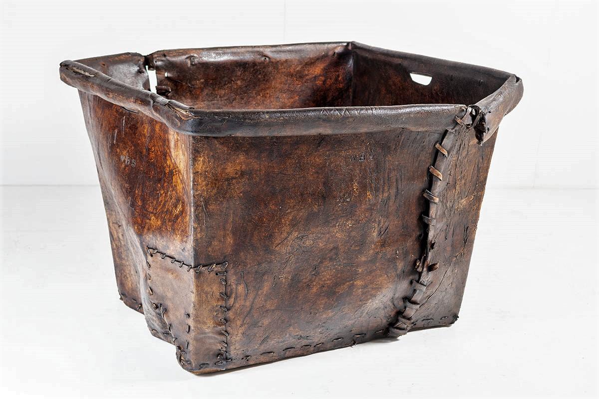 A superb example of a very large Pig Skin Leather Mill Basket, displaying great colour and wear and full of character.
Despite the various tears and patchwork repairs the basket is in very sound strong condition, the upper section has its original