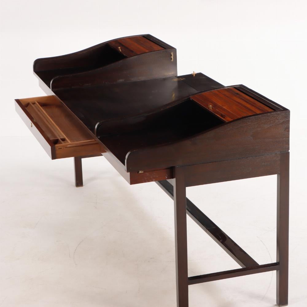 A rare Edward Wormley for Dunbar Executive Tambour Desk, model 912, circa 1957. The rosewood and walnut desk having two tambour roll-tops with a hinged panel at back drops down to form continuous work surface for use as a partner's desk. There are