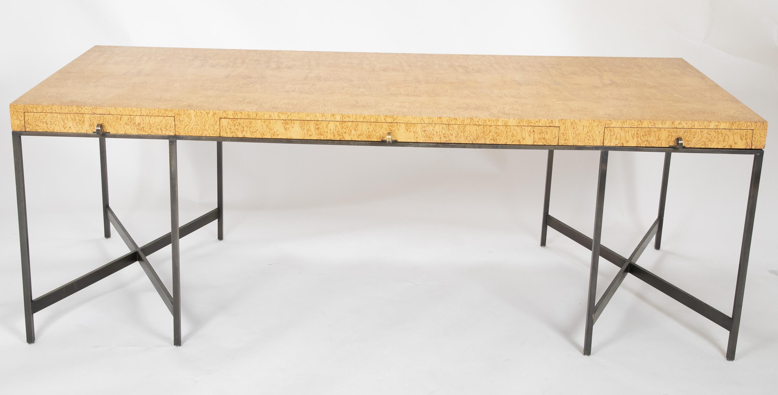 A rare Karelian birch burl desk. By repute a custom design by Edward Wormley for Dunbar. Desk rises on X-form bronze base with hand forged curled pulls.

 