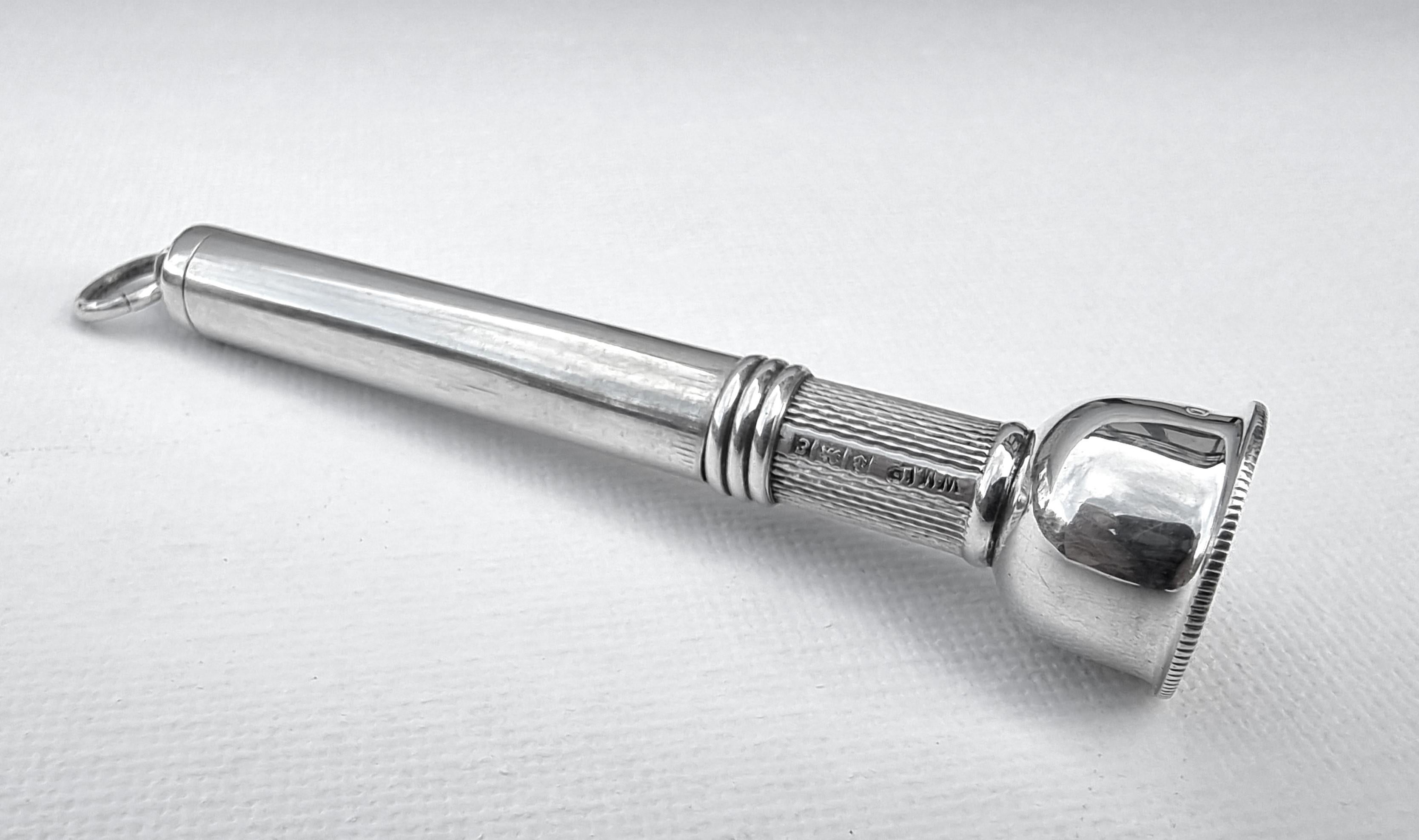 This rare and beautifully designed small item of silver is made in two parts. The upper stem is a slide off cover with a ring fitting which when removed exposes the engine turned spring loaded plunger which is designed to be pressed pushing the