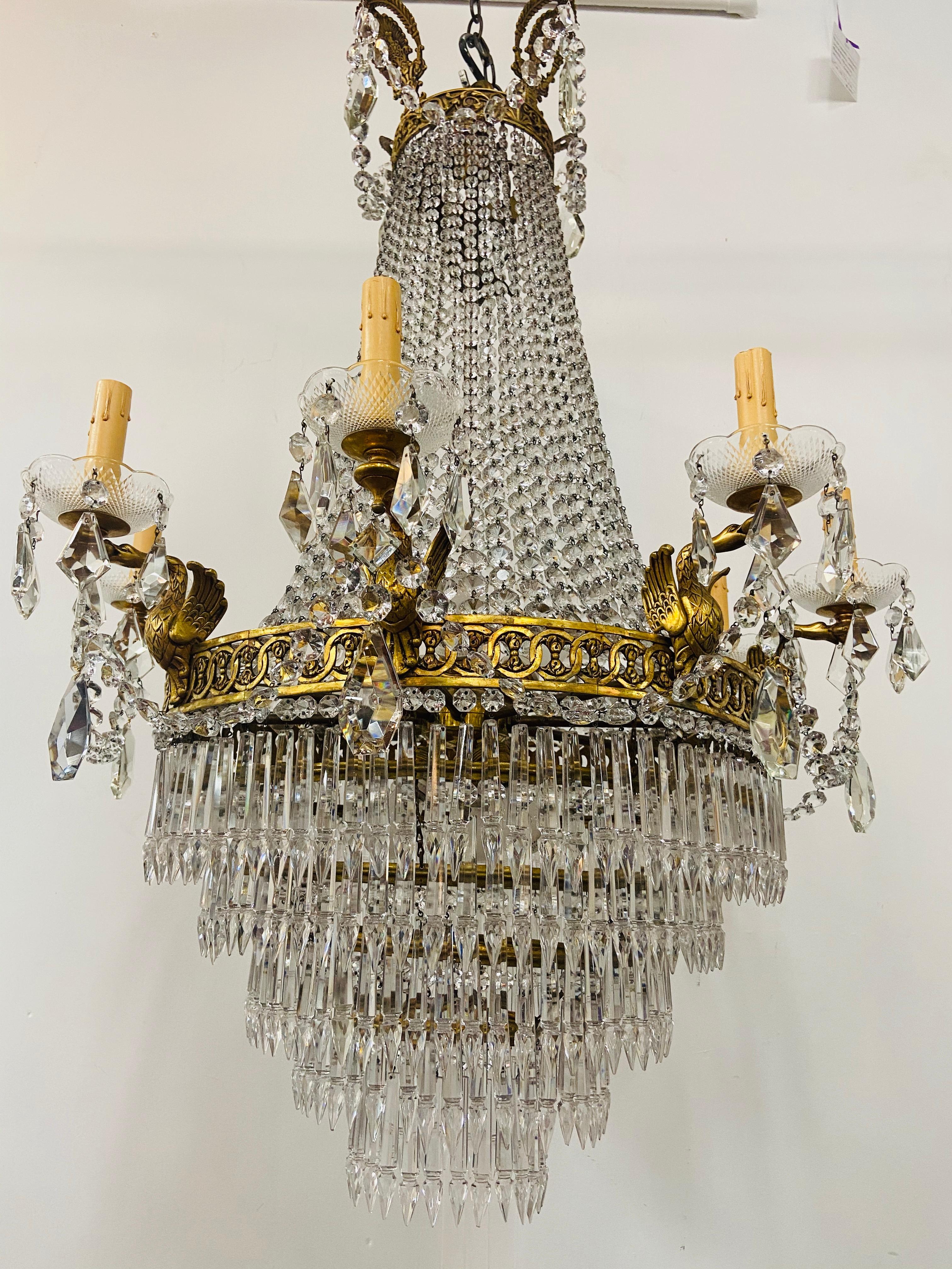 A rare 19th Century bonze and crystal French Louis XVI Empire style chandelier with 8 arms supported by a bronze ring and beaded crystal strands in a dome form top converging on a bottom finial and extending to top. The chandelier features 8 sturdy