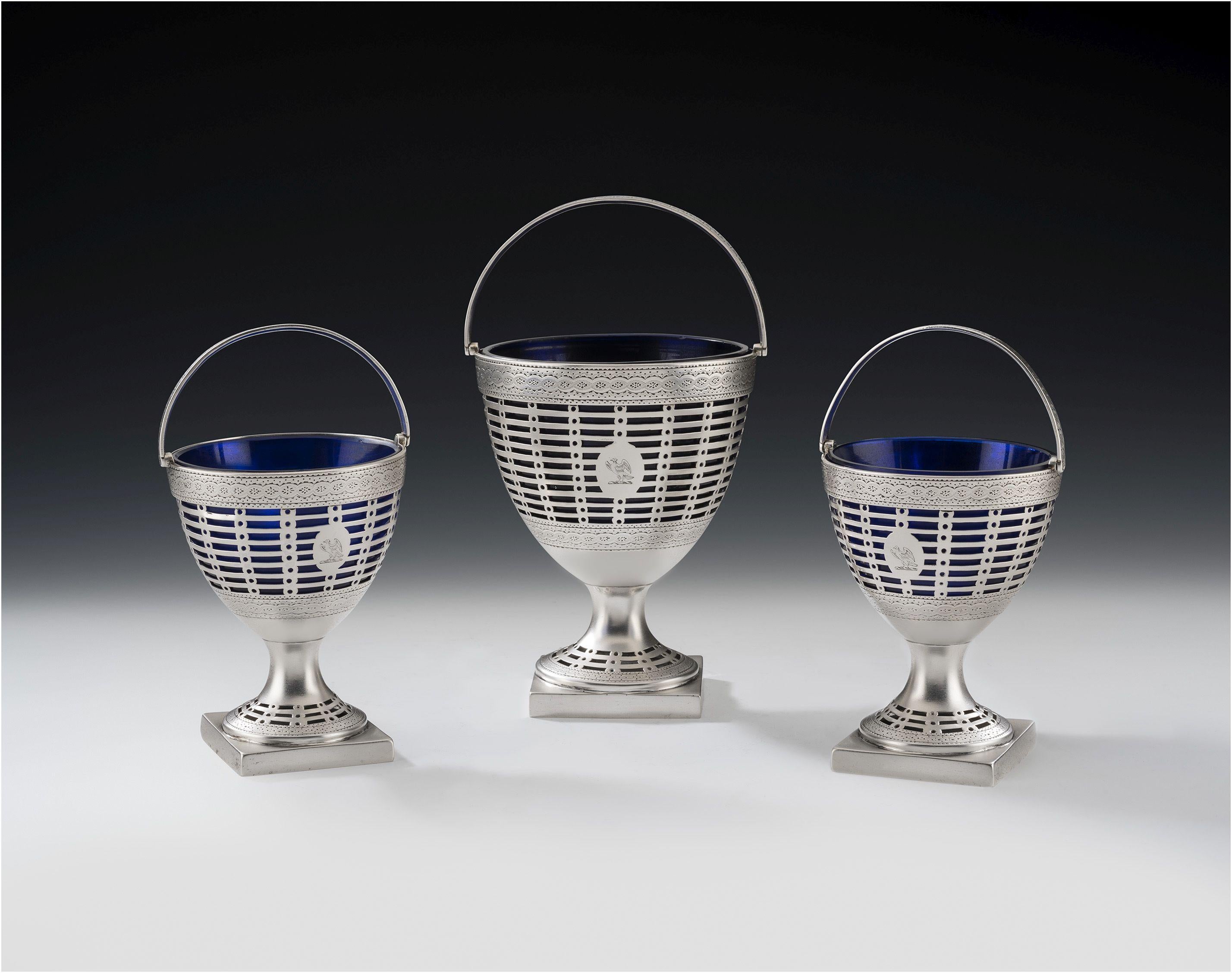 This extremely rare and fine garniture of George III neo classical baskets were made in London in 1778 by Philip Freeman. The Baskets all stand on a square pedestal foot which is pierced with horizontal pails and roundels, as well as being engraved