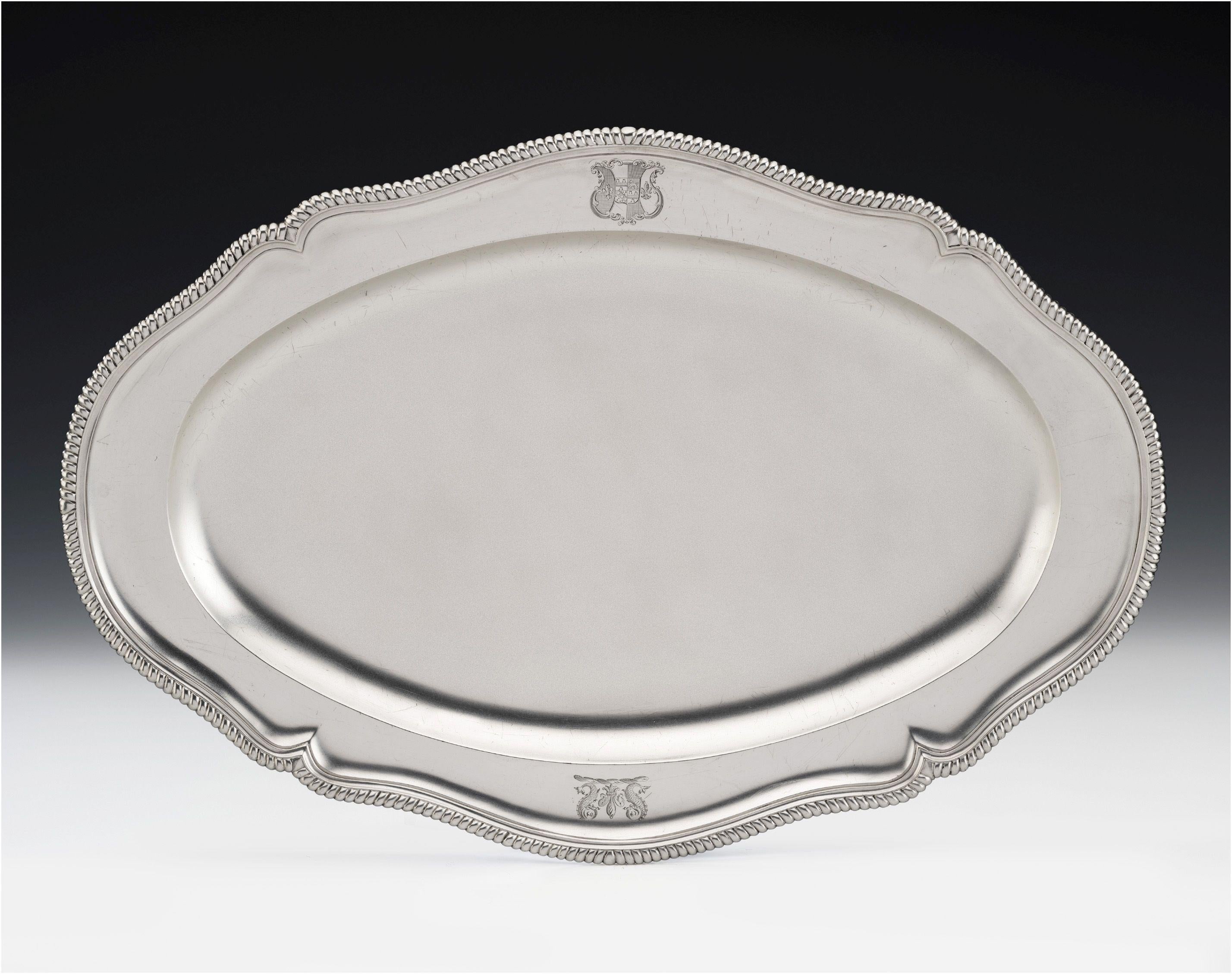 This exceptionally fine piece has an unusual elongated form, ideal for a salmon. The raised, shaped, border is decorated with unusual rounded gadrooning and the border is engraved on one side with a contemporary Armorial and on the other with an