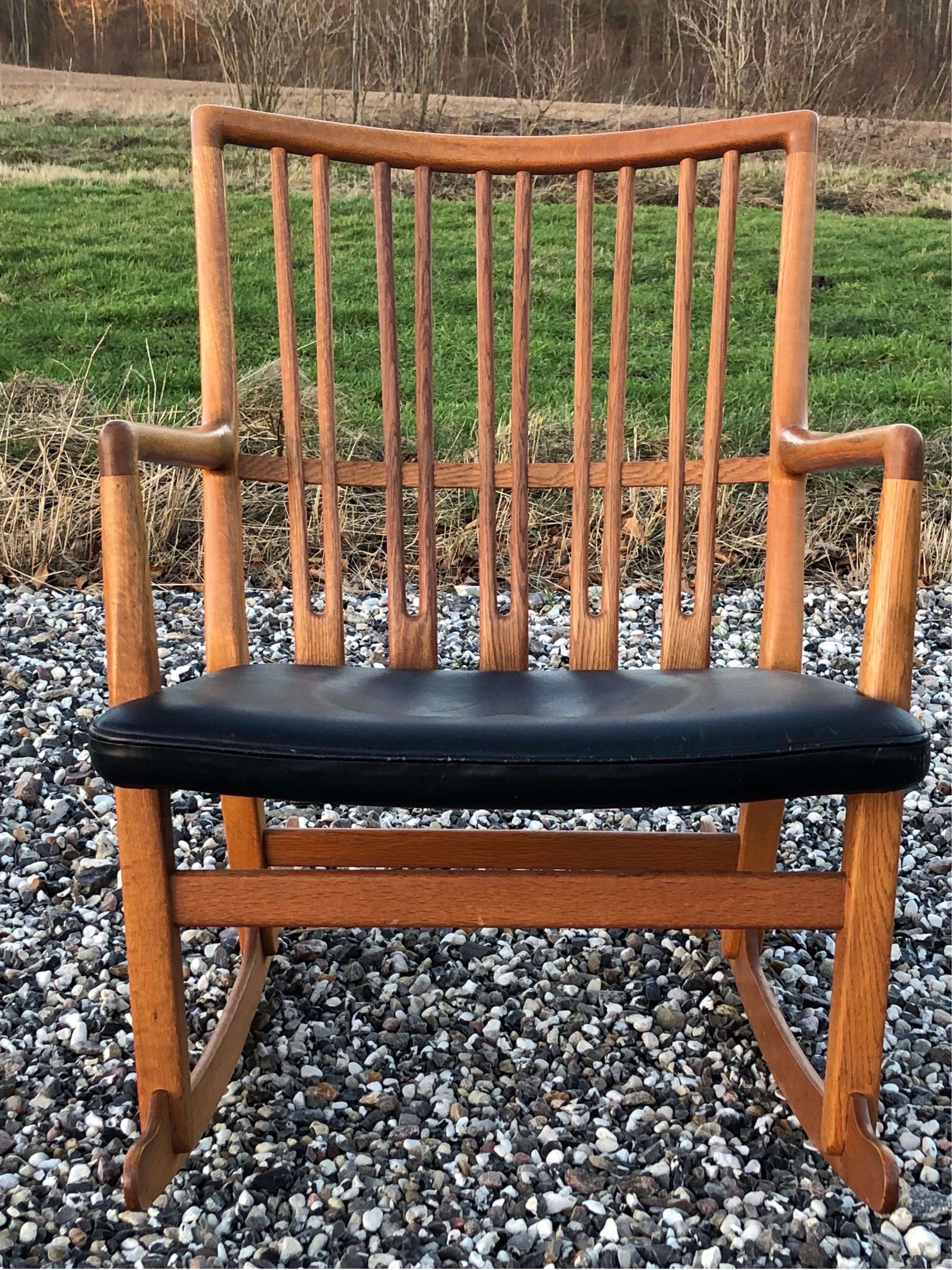 Un raro sillón Hans J. Wegner Rocker de roble macizo de la década de 1940.  Realizado por Mikael Lauersen. Cuero negro patinado original.