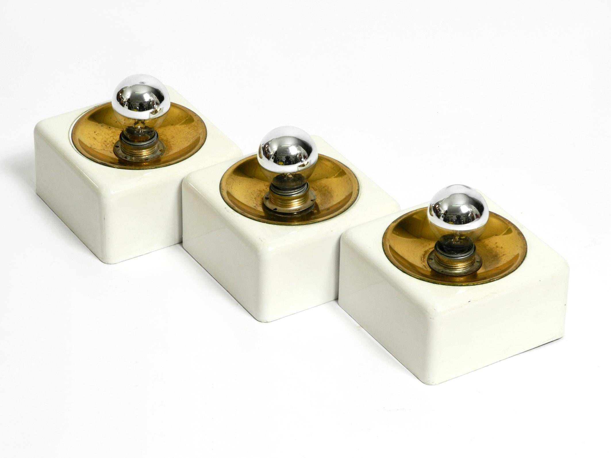 A rare Italian Space Age metal and brass ceiling or wall lamp.
The three screwed cubes are made of white lacquered metal, the reflectors are made of brass.
Each cube has an E14 original socket.
Great Space Age design.
Lamps are without damage