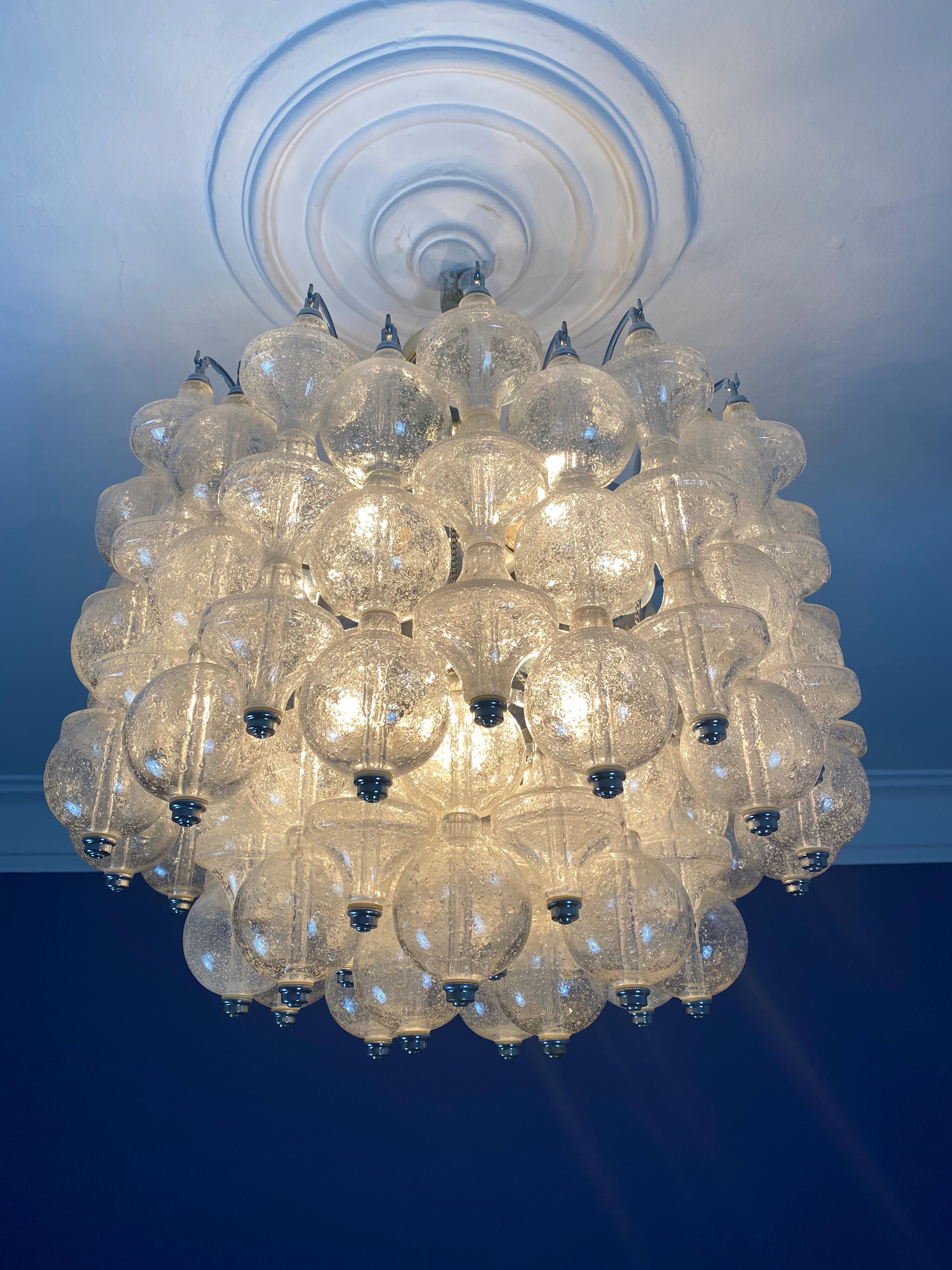 A rare large and bright 1970s Murano Seguso ball chandelier by Distributeur: OTT International, Hamburg, Germany.

Alternating ball-shaped and tulip-shaped clear pulegoso glass elements mounted on a clear Lucite tube and partly on small