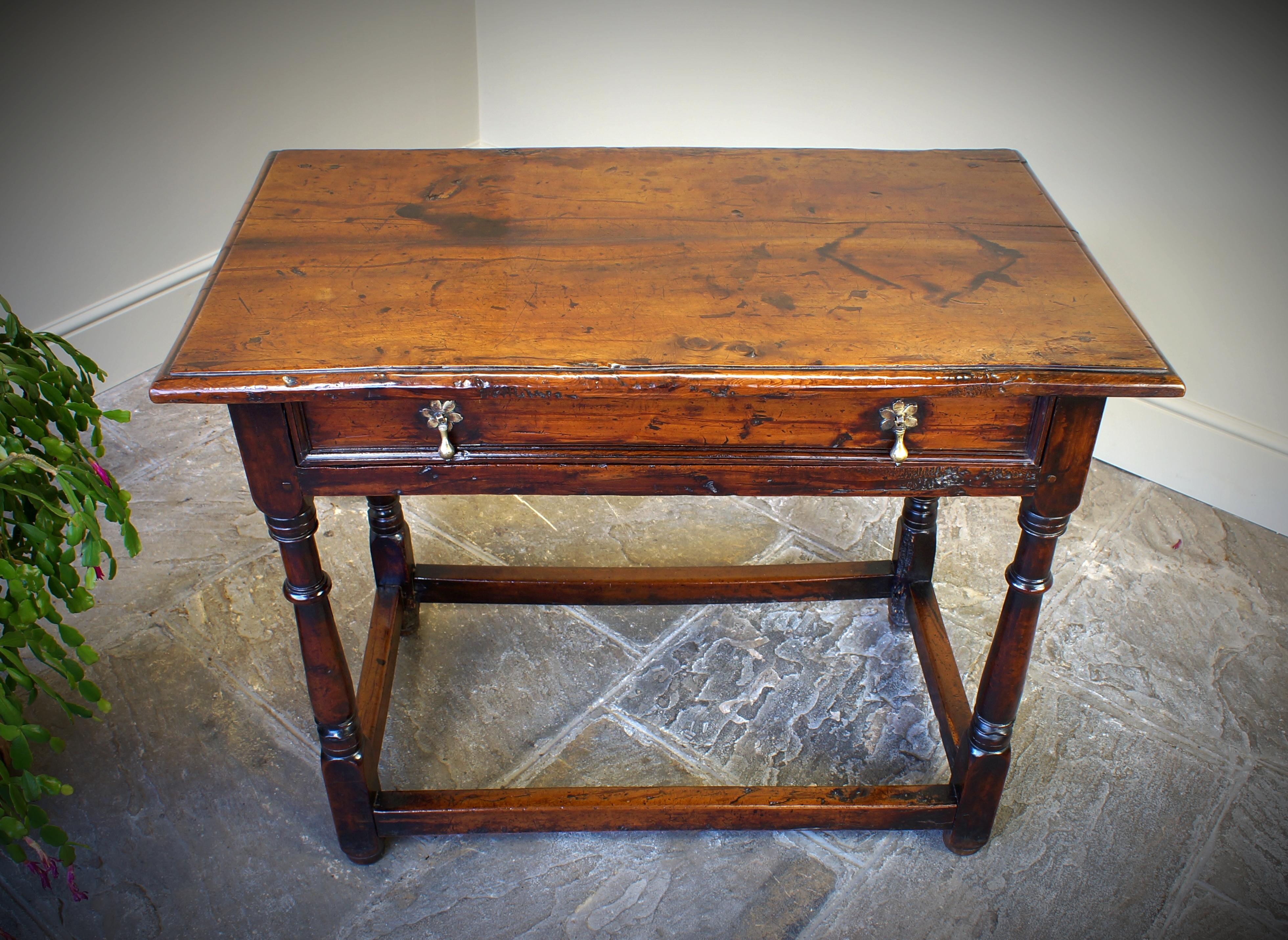 A rare late 17th century (circa 1690) yew wood side table having exceptional colour and surface.
The two piece top above a moulded drawer, having four well turned legs united by peripheral stretchers
A rare example in fine original condition.
Yew is