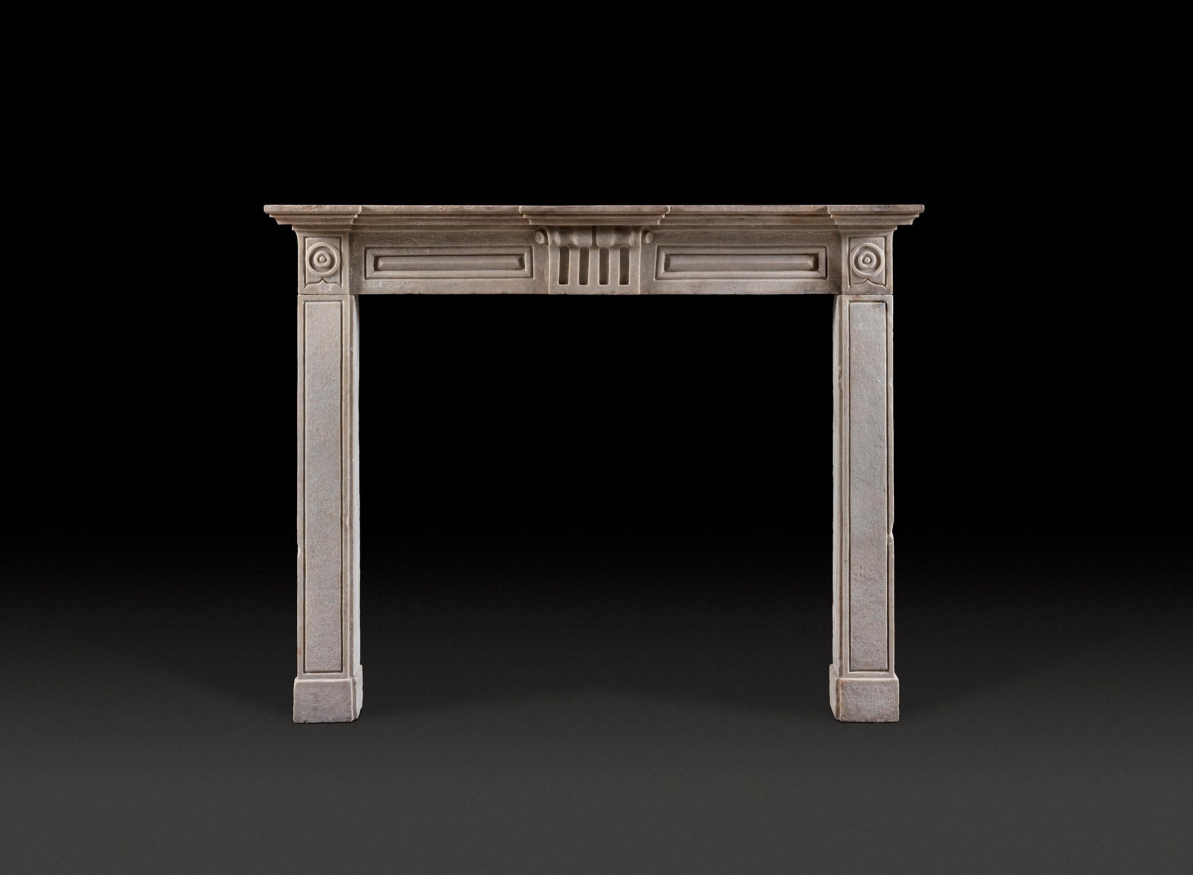 Une cheminée italienne rare et bien proportionnée, sculptée dans la région du Piémont vers la fin du XVIIIe siècle. Une simple étagère de façade repose sur une frise lambrissée sculptée au centre d'une tablette cannelée surmontée d'une élégante