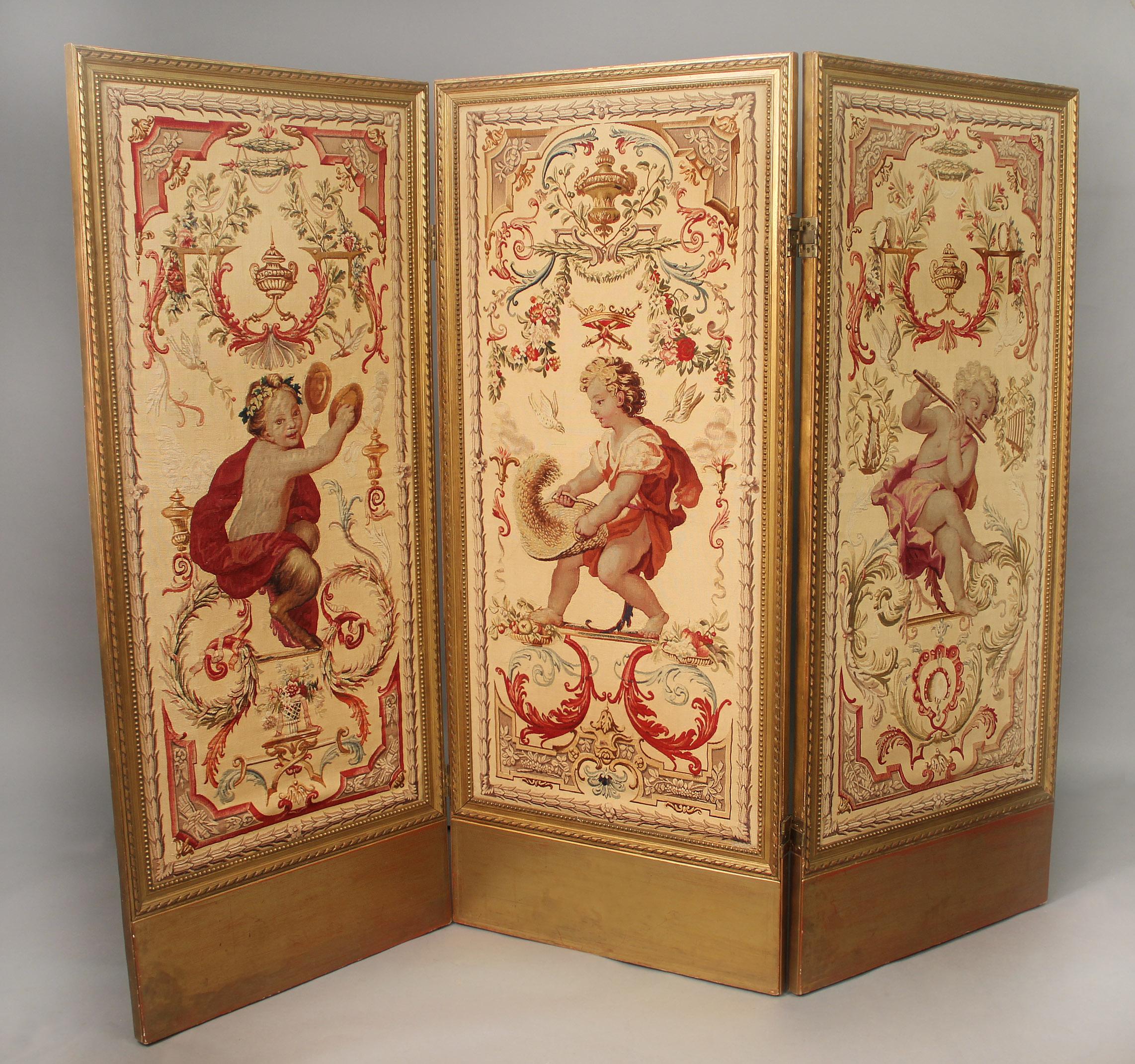 The rectangular shaped wonderful quality woven panel screen still has its original vivid colors. One panel with a Faun playing hand cymbals and depicting mythology, another with a child gathering wheat symbolizing farming and the last with a putti