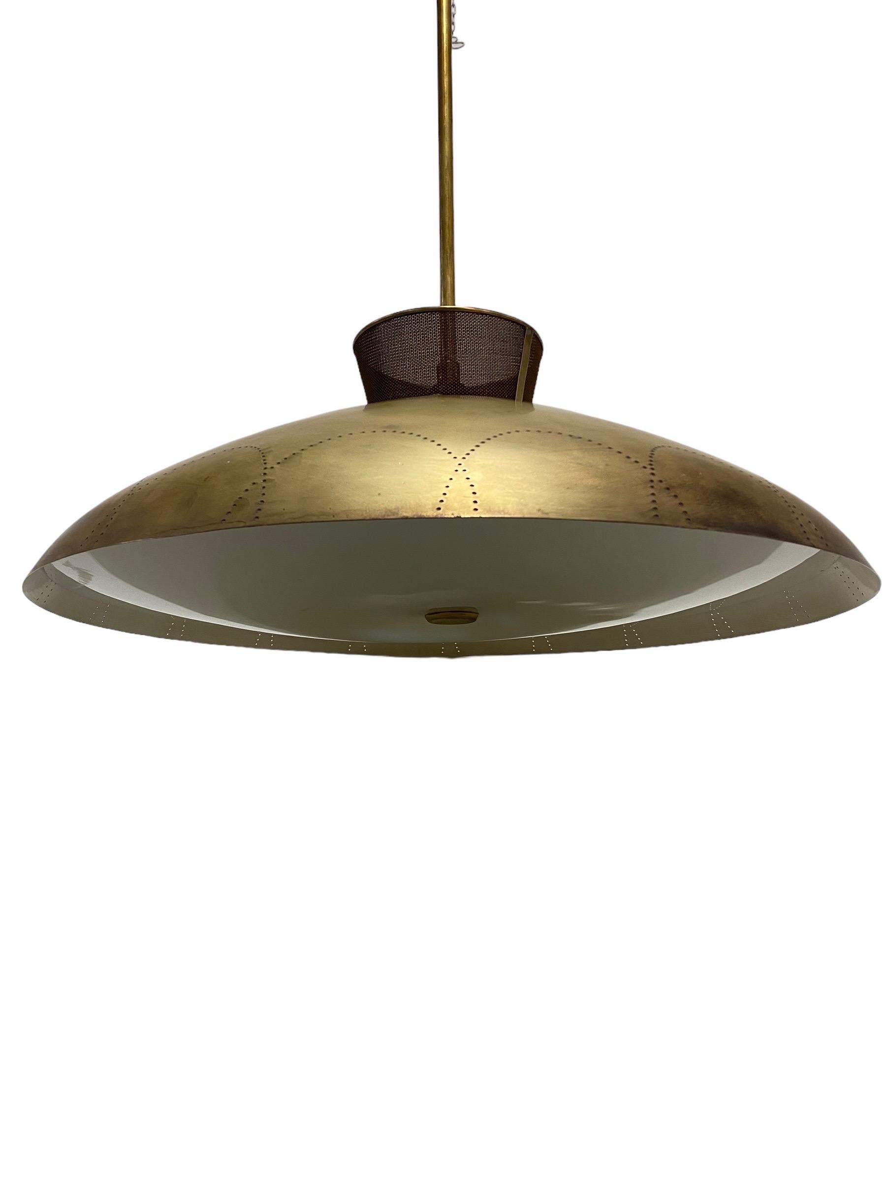 A rare Lisa Johansson-Pape brass ceiling lamp, manufactured by Orno Oy in Finland in the 1950s. A beautiful design with a brass shade that has distinctive perforations that make the lamp stand out when the light is turned on. The lamp is in overall