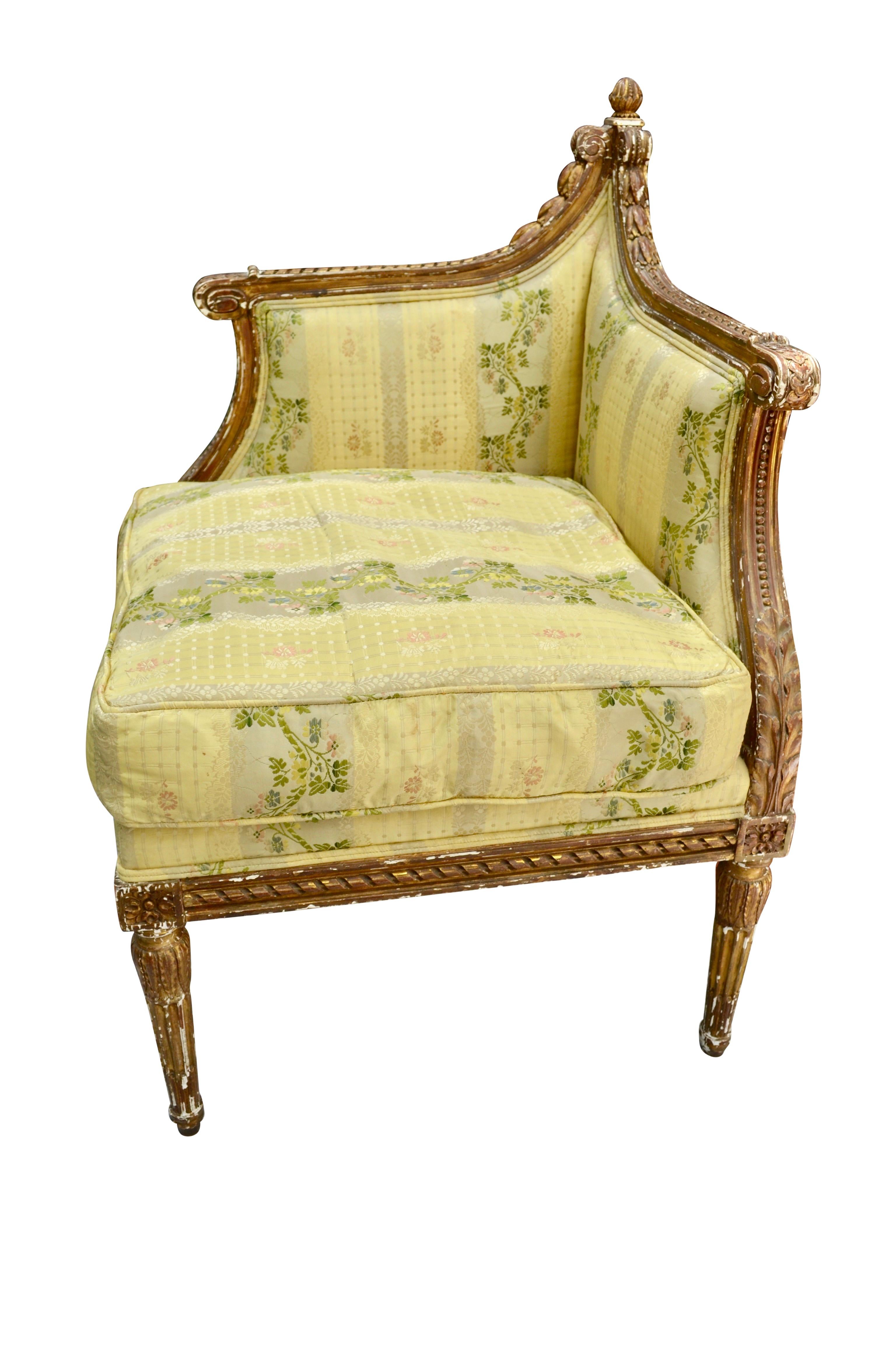 A rare and unusual carved and gilt corner chair of the Louis XVI period. The frame is totally carved with scroll work, rosettes, ribbons, with a decorative 'acorn' at the back corner of the chair. The gilding on the chair is original but suffers