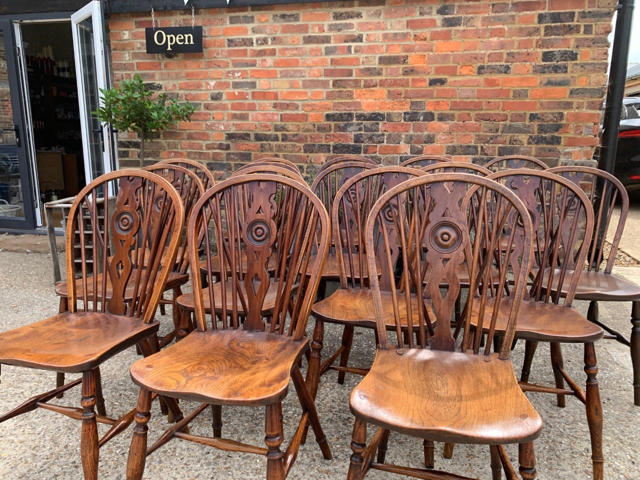 19th century set of Windsor draught back chairs with shaped elm seat; raised on bobble turned legs united by an H-stretcher. The chairs retain an excellent color and they are very closely matched. Measures: H x 35