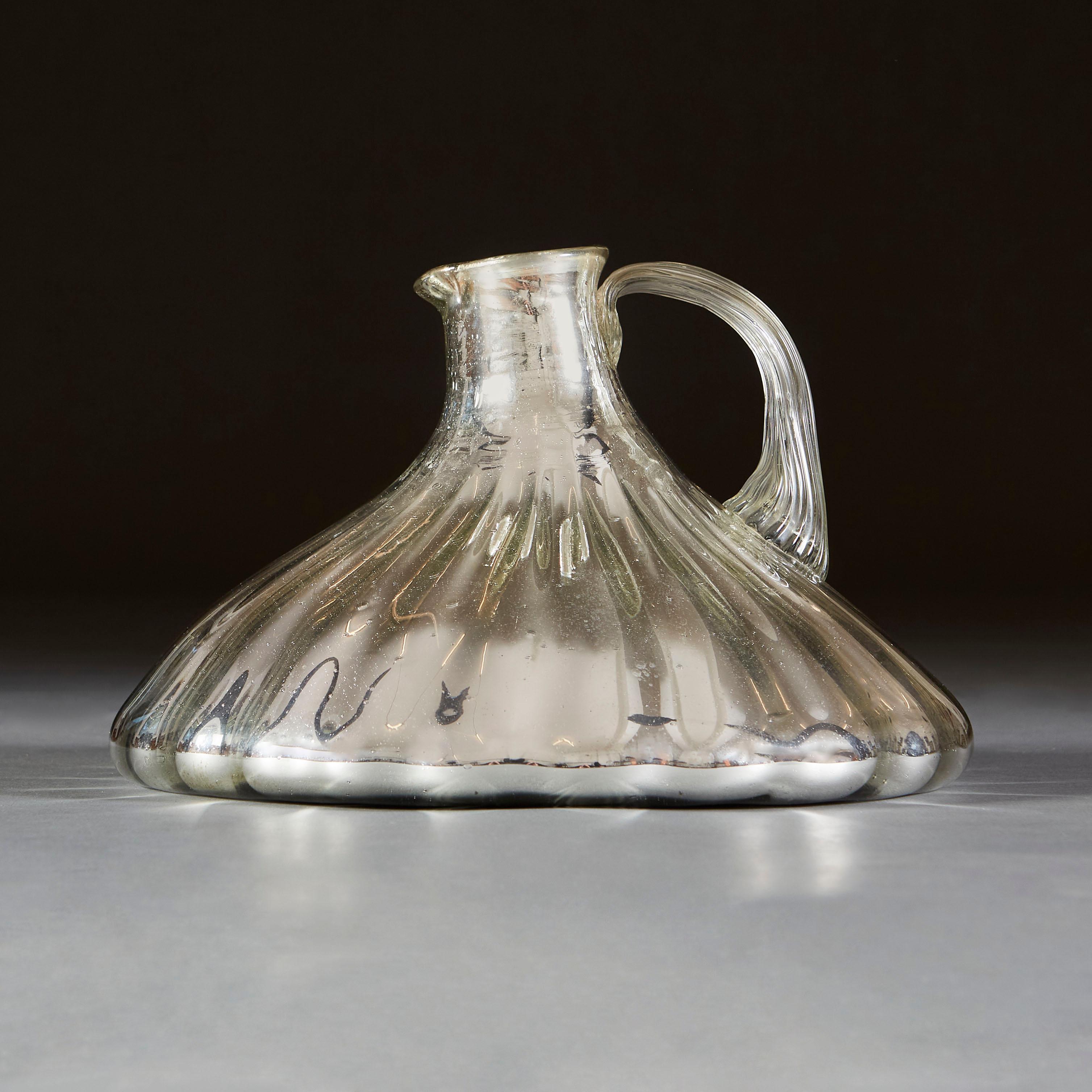 An unusual early twentieth century mercury glass jug, with vertical gadrooning throughout and a clear glass handle.