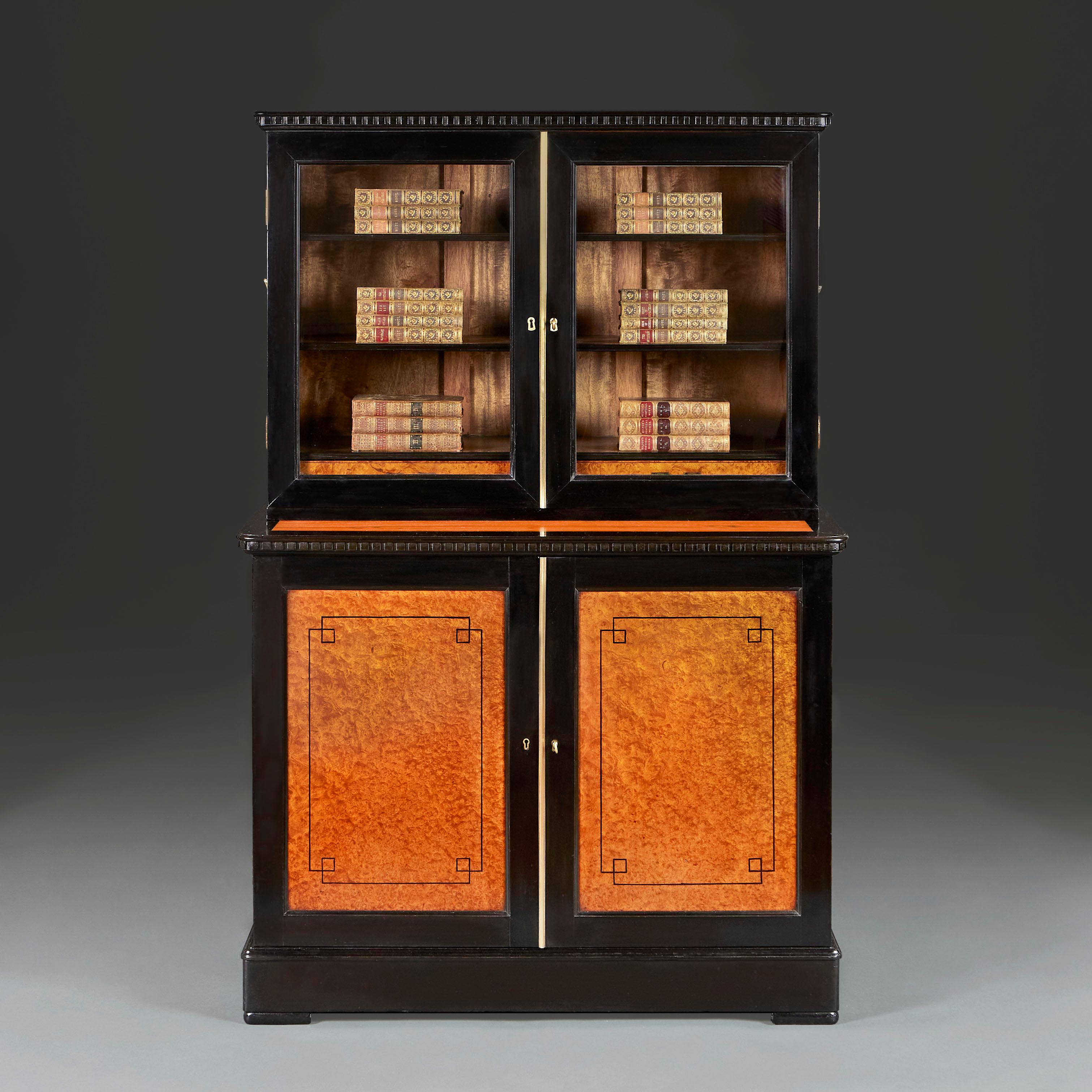 Anglo Chinese, circa 1860

A rare mid nineteenth century Anglo Chinese campaign amboyna and ebonised bookcase with glazed upper section, the doors revealing three shelves and two drawers, above a dental cornice, the lower section with cupboard doors