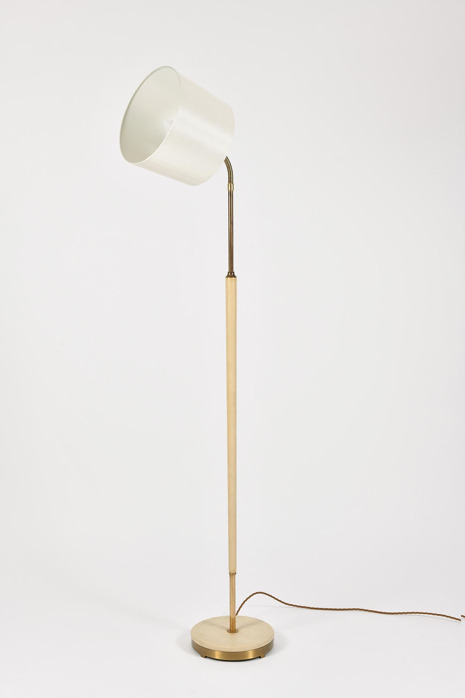 A rare brass and cream leather floor lamp, the adjustable goose-neck holding a 'reading' light with an off-white silk lampshade
Sweden, circa 1950.