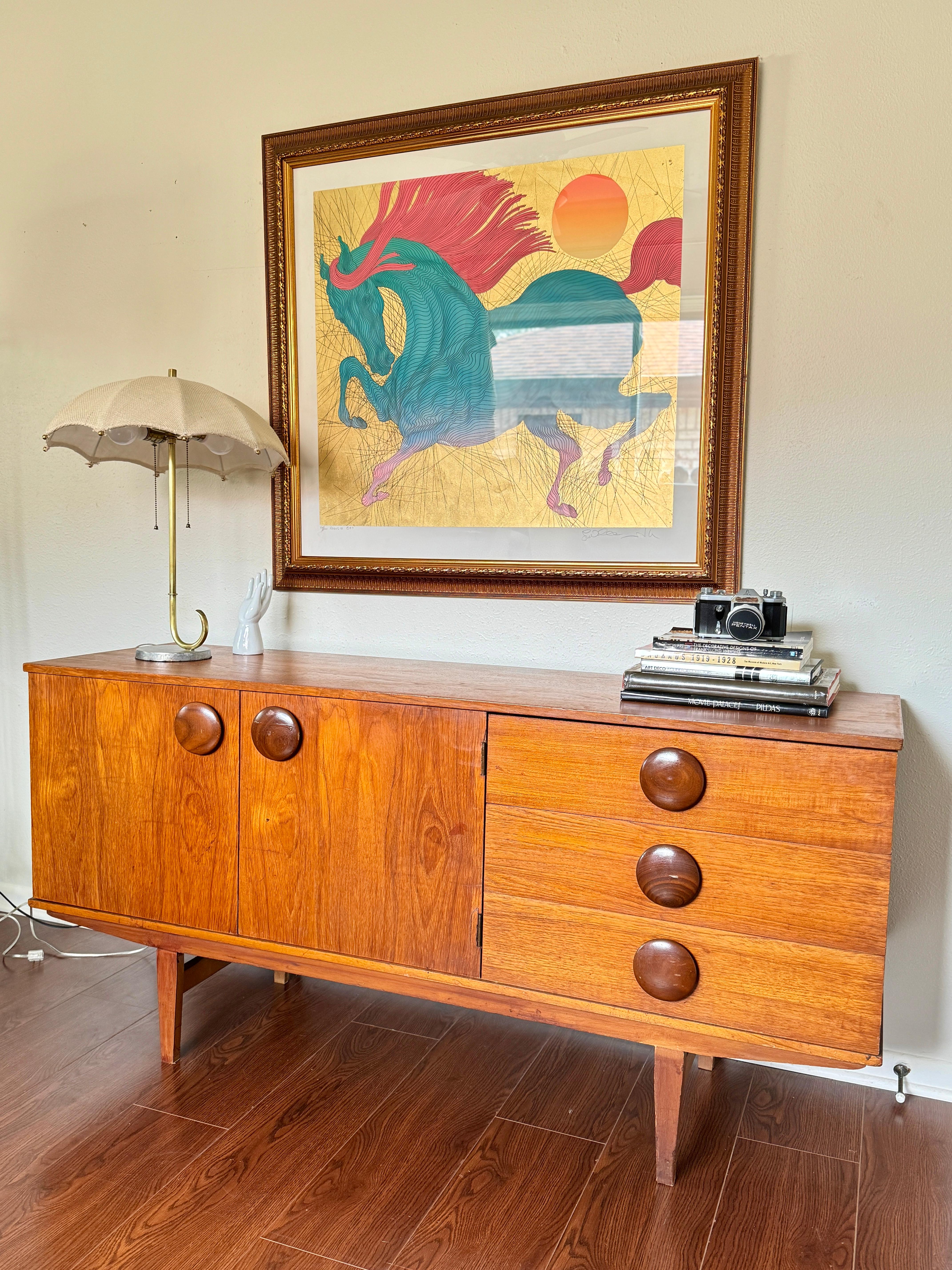 A rare mid century modern sideboard with round wooden pulls, circa 1960s. Maker is unknown. Structurally sound and all drawers open and close smoothly, but there are some cosmetic flaws. Please see photos.

29” H x 60” W x 17.5” D
