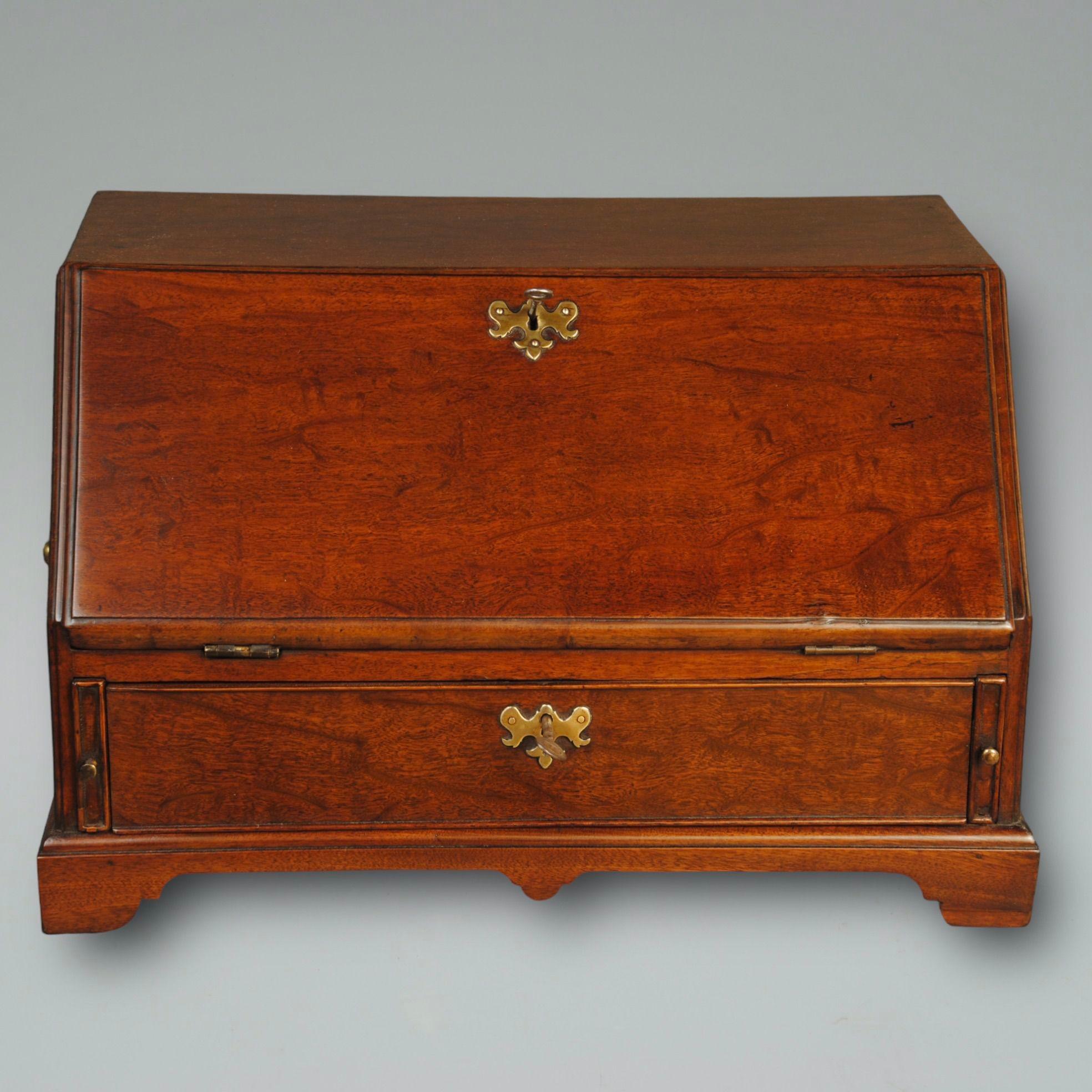 A super plum pudding mahogany miniature table bureau with a beautiful curved fitted interior and original brass carrying handles 
Circa 1740