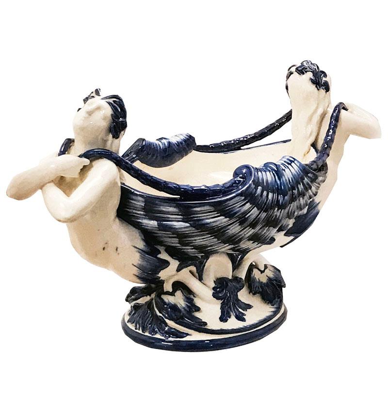 A rare Minton glazed earthenware mermaid centrepiece c.1875 designed by Albert Carrier Bellouse ( Rodins teacher). The oval body designed a open conch shell supported by outward facing mermaids at each end, all supported on an oval, m base of shell