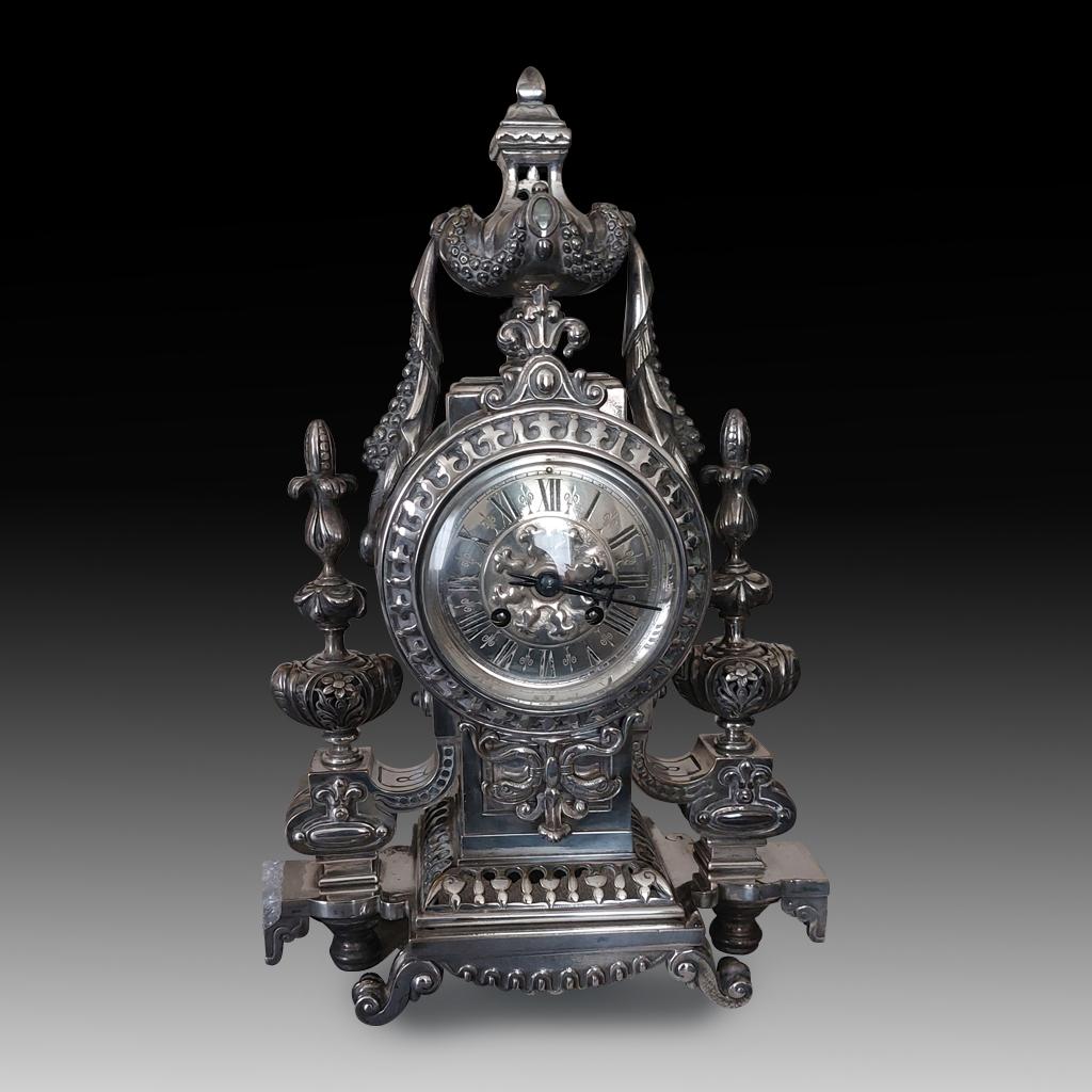 This is a superb, highly decorative original, and rare authentic antique French Empire silvered bronze mantel clock, circa. 1870. The work is rendered in an elegant neoclassical style and is finely crafted from bronze and silver. The impressive