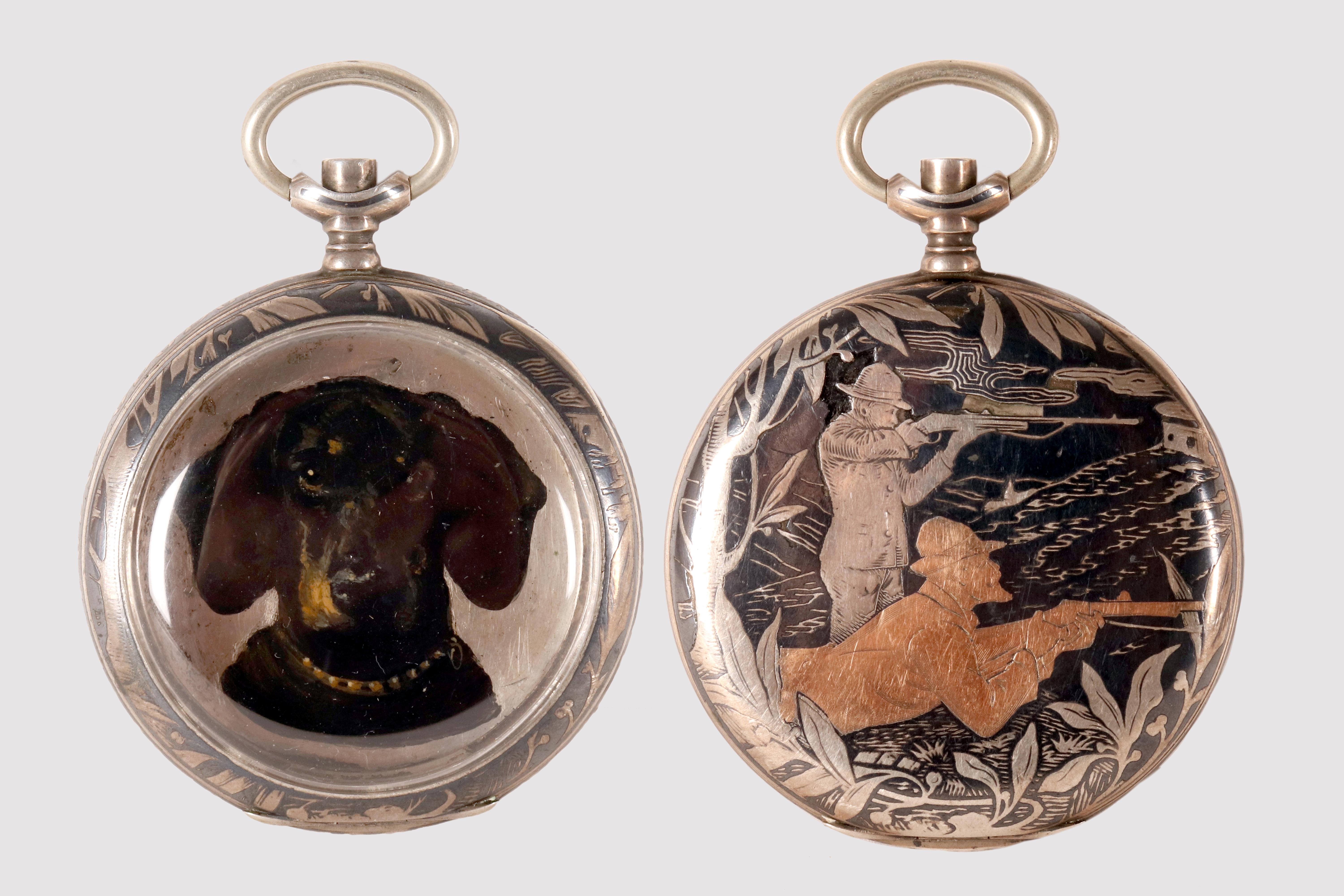 La cassa dell'orologio da tasca è in argento 800/100. L'intero fondello della cassa è decorato con la tecnica del niello, un raffinato intarsio di una lega metallica nera nelle scanalature o negli spazi lasciati dall'incisione di una superficie
